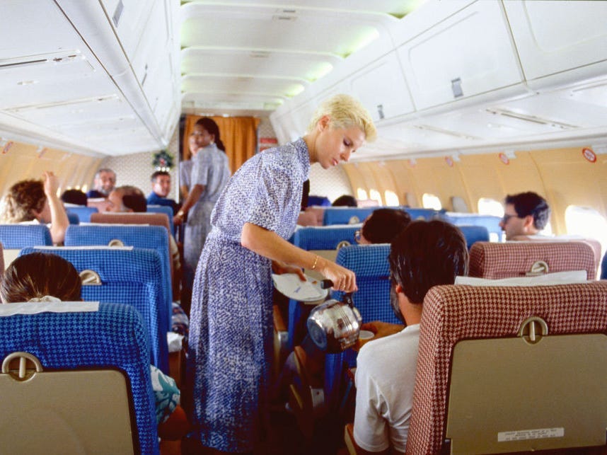 Stewardess betreut einen Reisenden 1986, Reise von Madrid nach Barcelona, ​​Spanien.