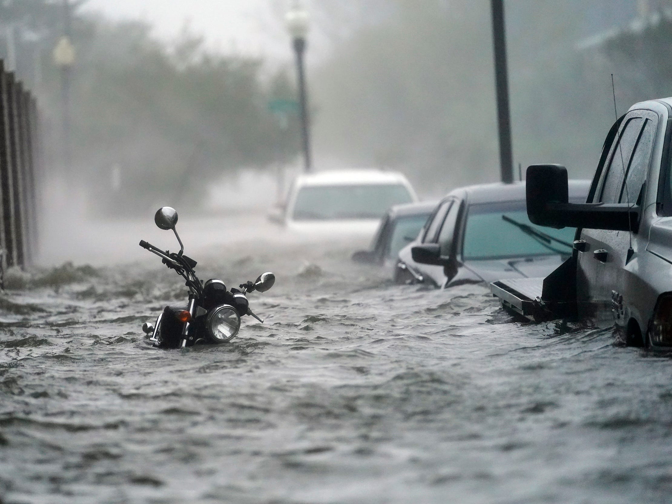 Motorräder und eine Reihe von Autos ragen über dem Hochwasser hervor