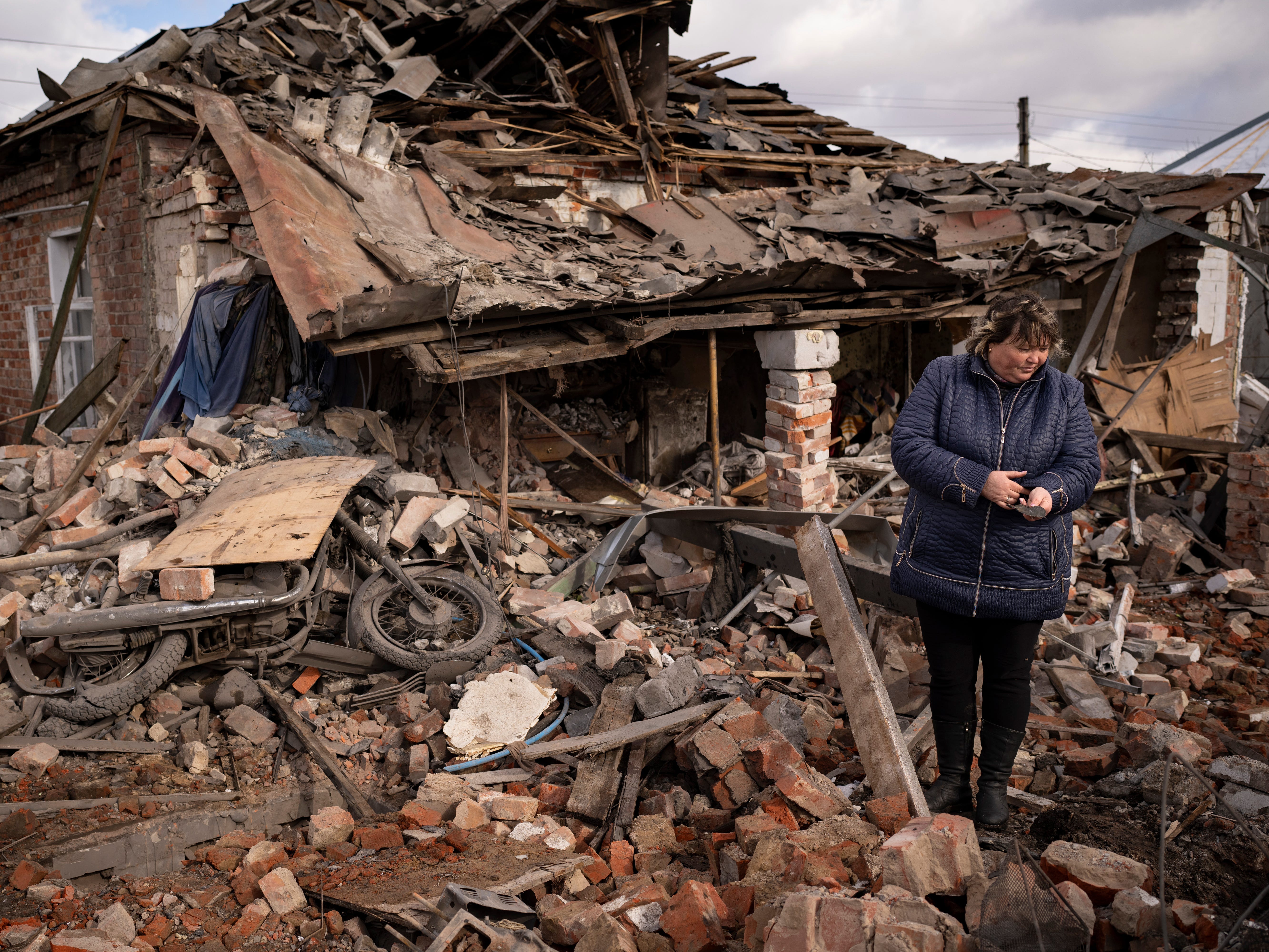 Eine Frau hält ein Splitterstück in den Trümmern eines Hauses in Kupiansk, Ukraine, in dem ukrainische Soldaten Schutz suchten und das durch einen russischen S-300-Raketenangriff zerstört wurde.