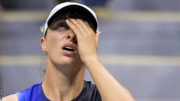 Iga Swiatek bedeckt ihr Gesicht während einer US-Open-Niederlage gegen Jelena Ostapenko