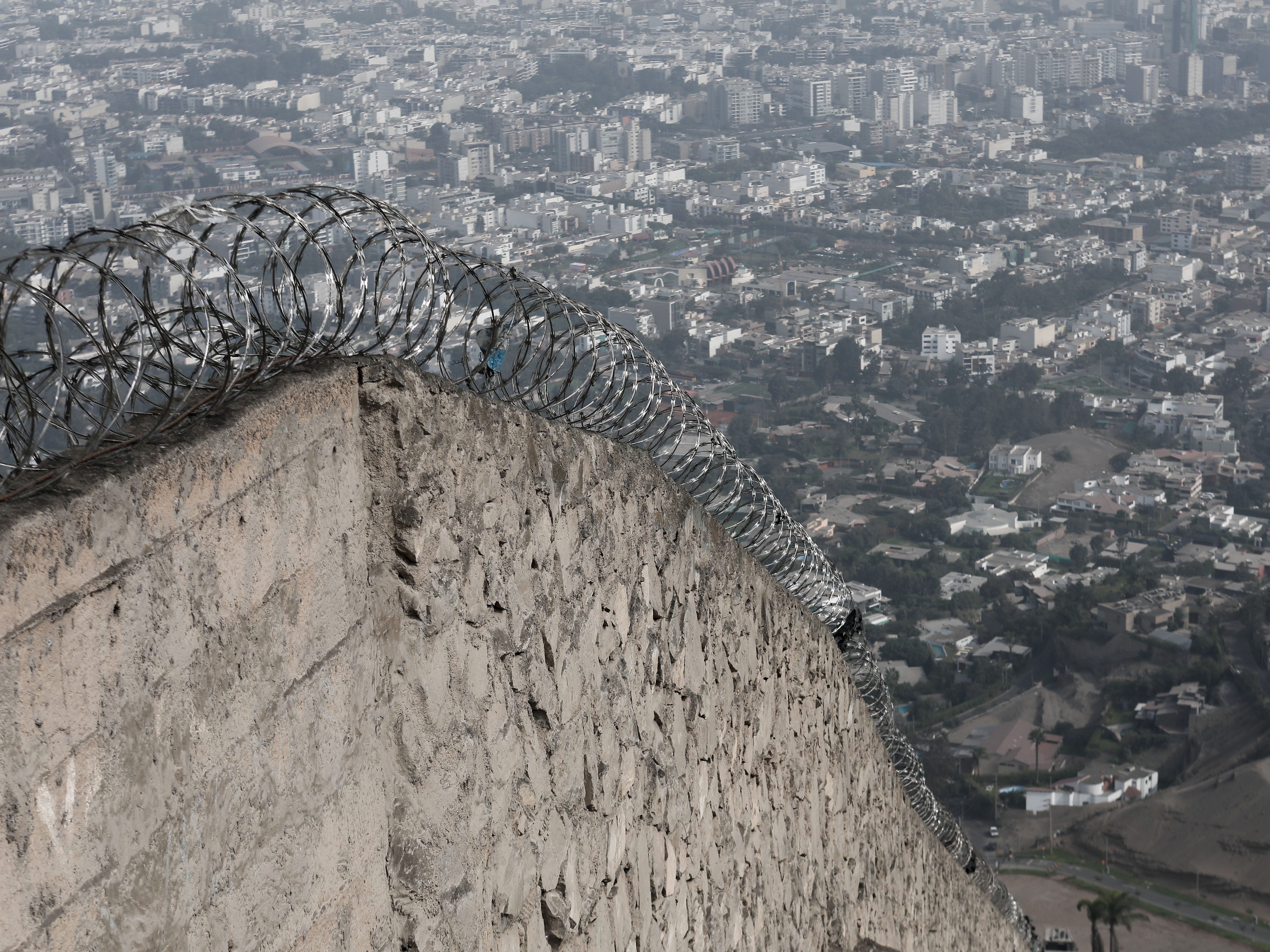 Ein Blick auf die „Mauer der Schande“, die die exklusivsten und wohlhabendsten Gebiete im Bezirk Santiago de Surco von einer wirtschaftlich benachteiligten Zone im Bezirk San Juan de Miraflores in Lima, Peru, trennt.