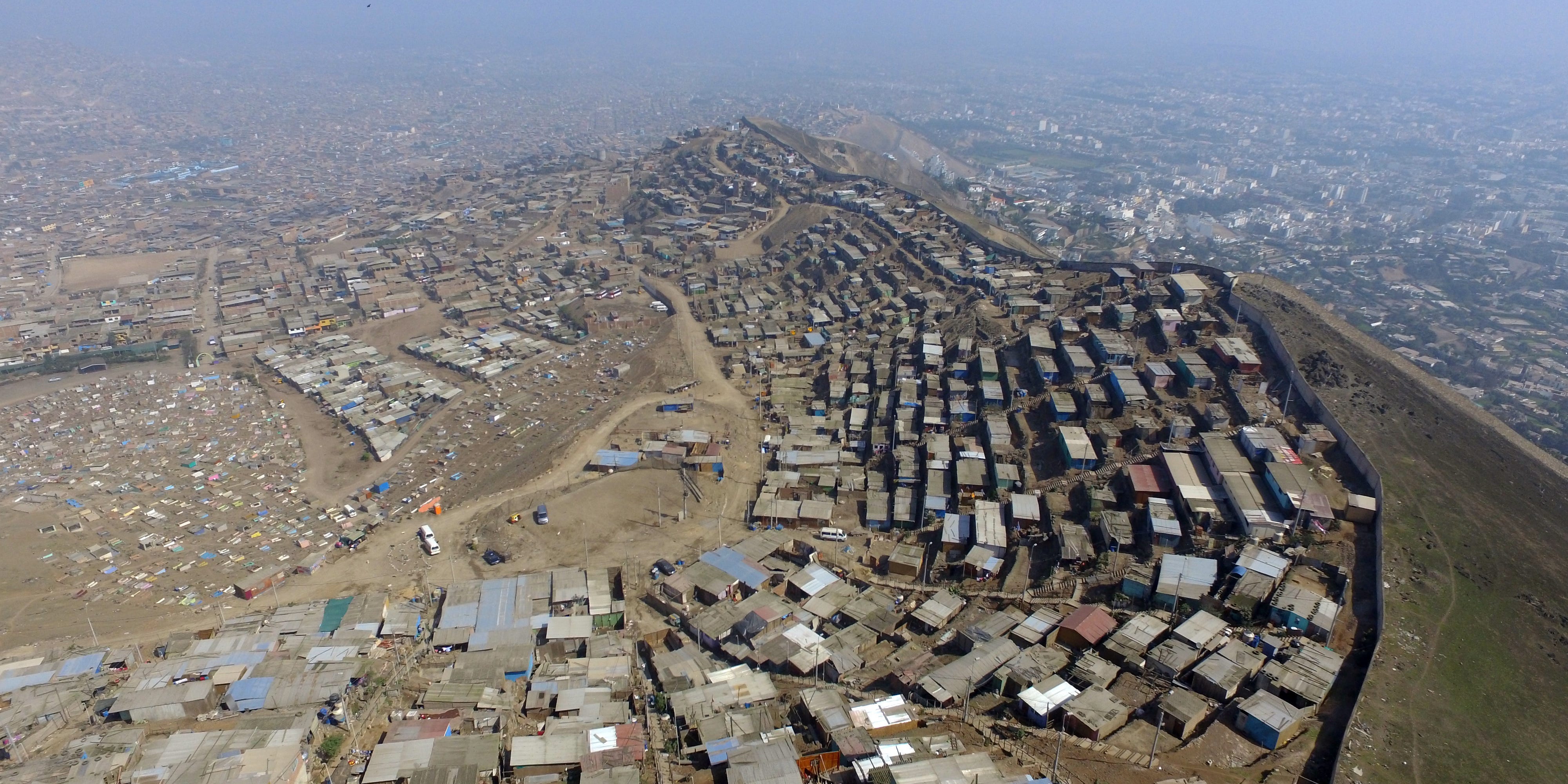 Luftaufnahme von Lima über der Mauer, die das Slum von Pamplona vom Mittel- und Oberschichtviertel Santiago de Surco trennt.