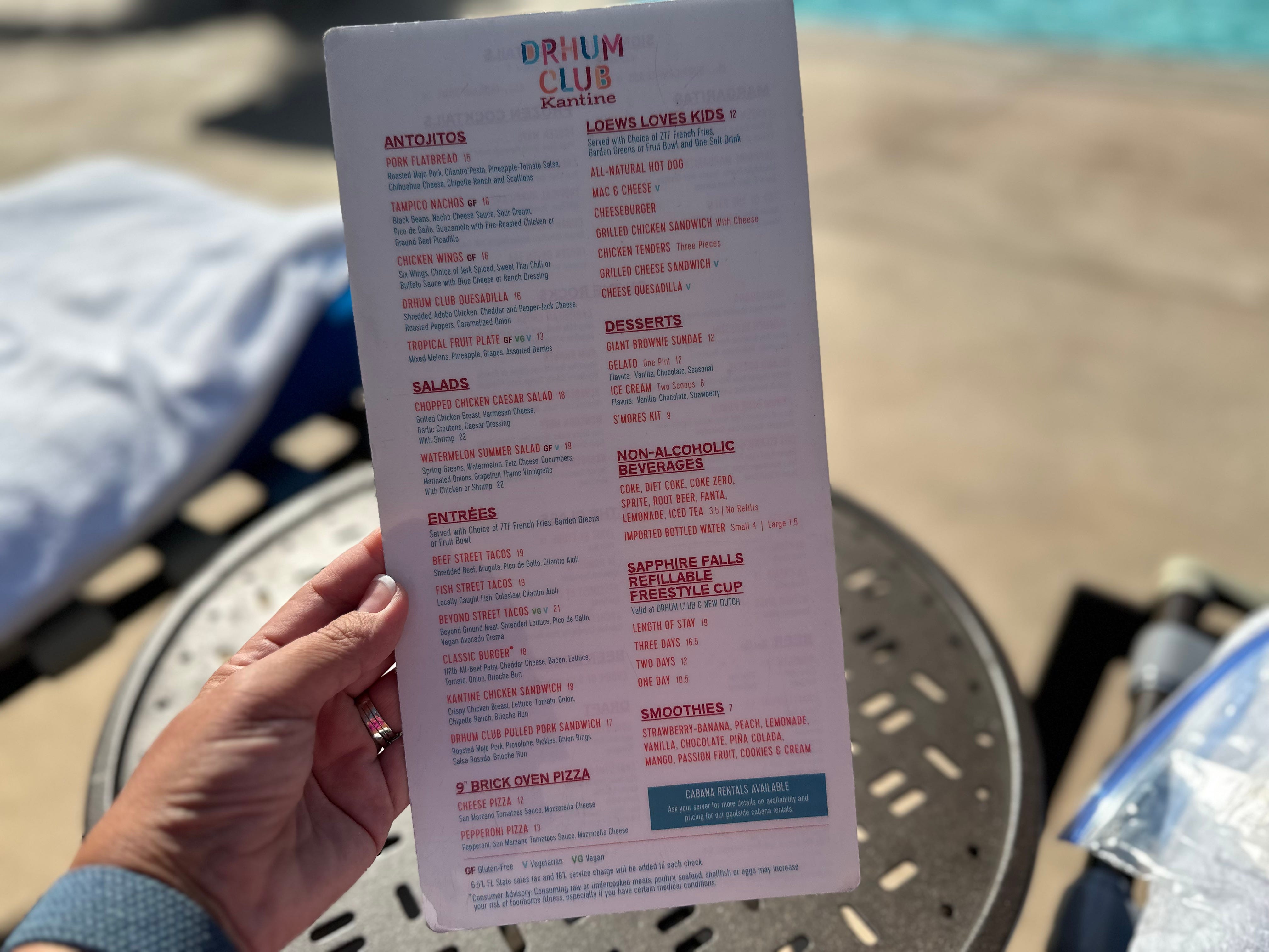 Hand hält Essens- und Eisbahnmenü in den Cabanas im Loews Sapphire Falls Resort in Universal Orlando