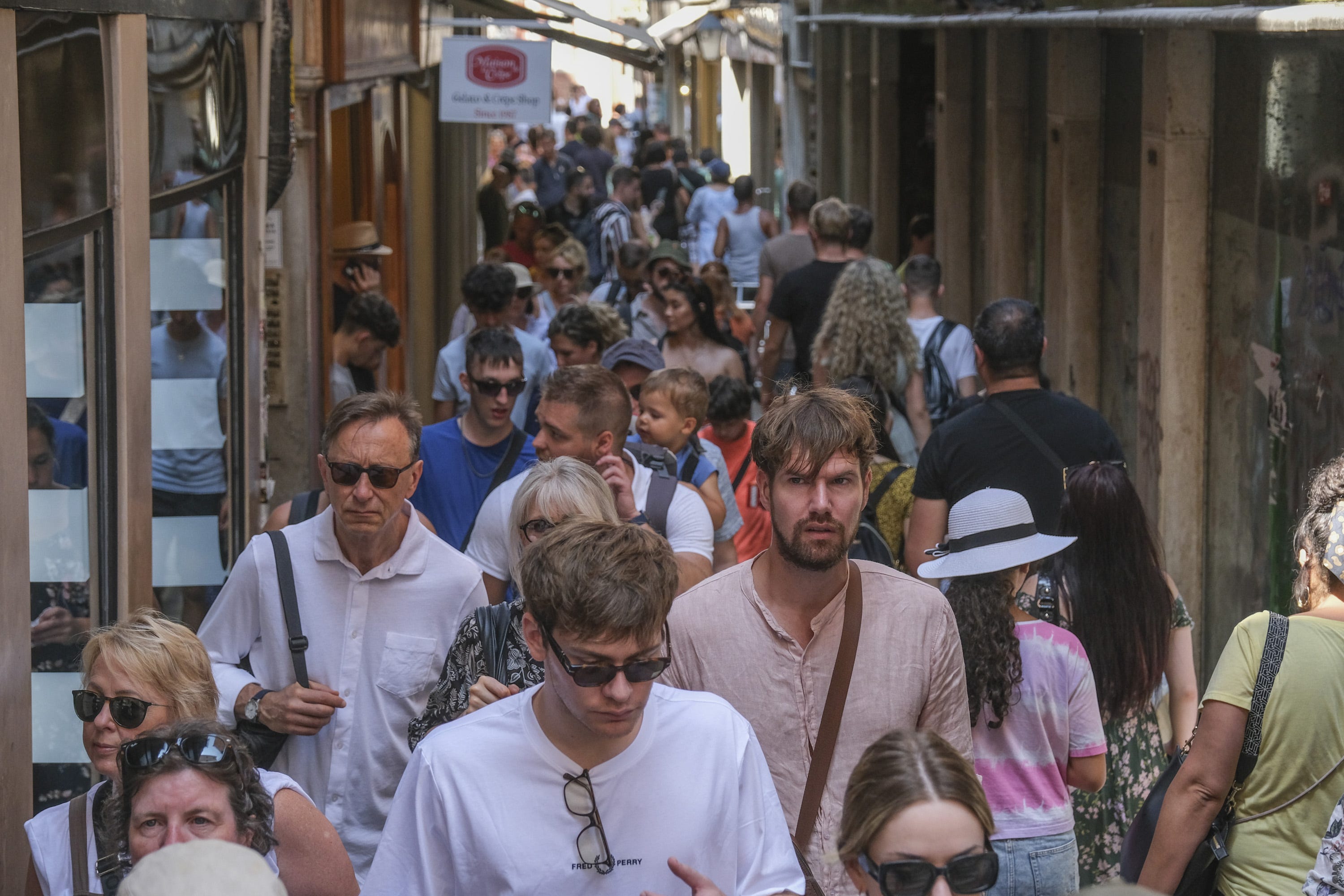 Touristen gehen am 2. August 2023 in Venedig, Italien, durch eine kleine Calle in der Nähe von Rialto.