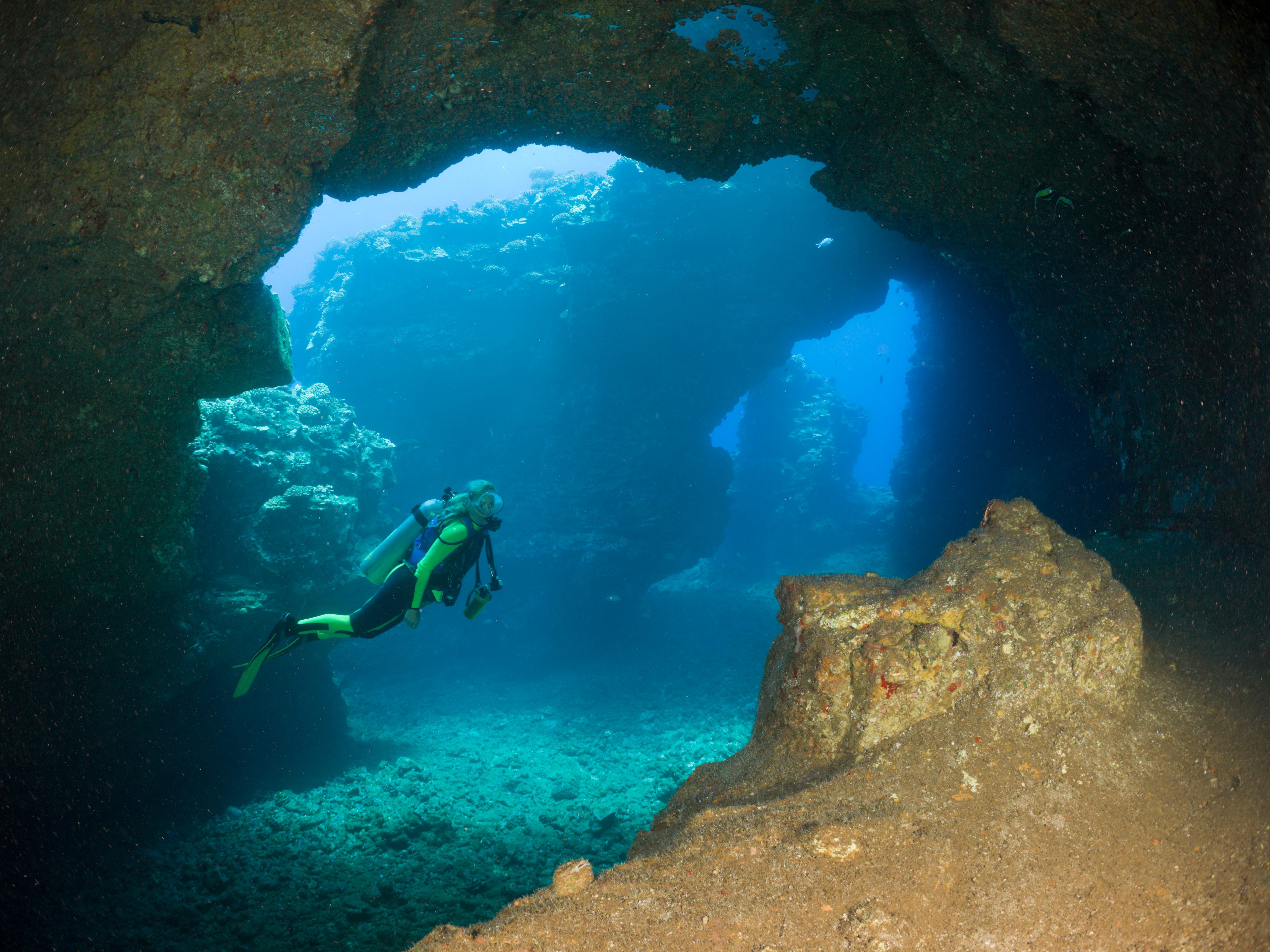 Ein Taucher schwimmt in den Höhlen der Lavaröhren, den Kathedralen von Lanai, Maui.