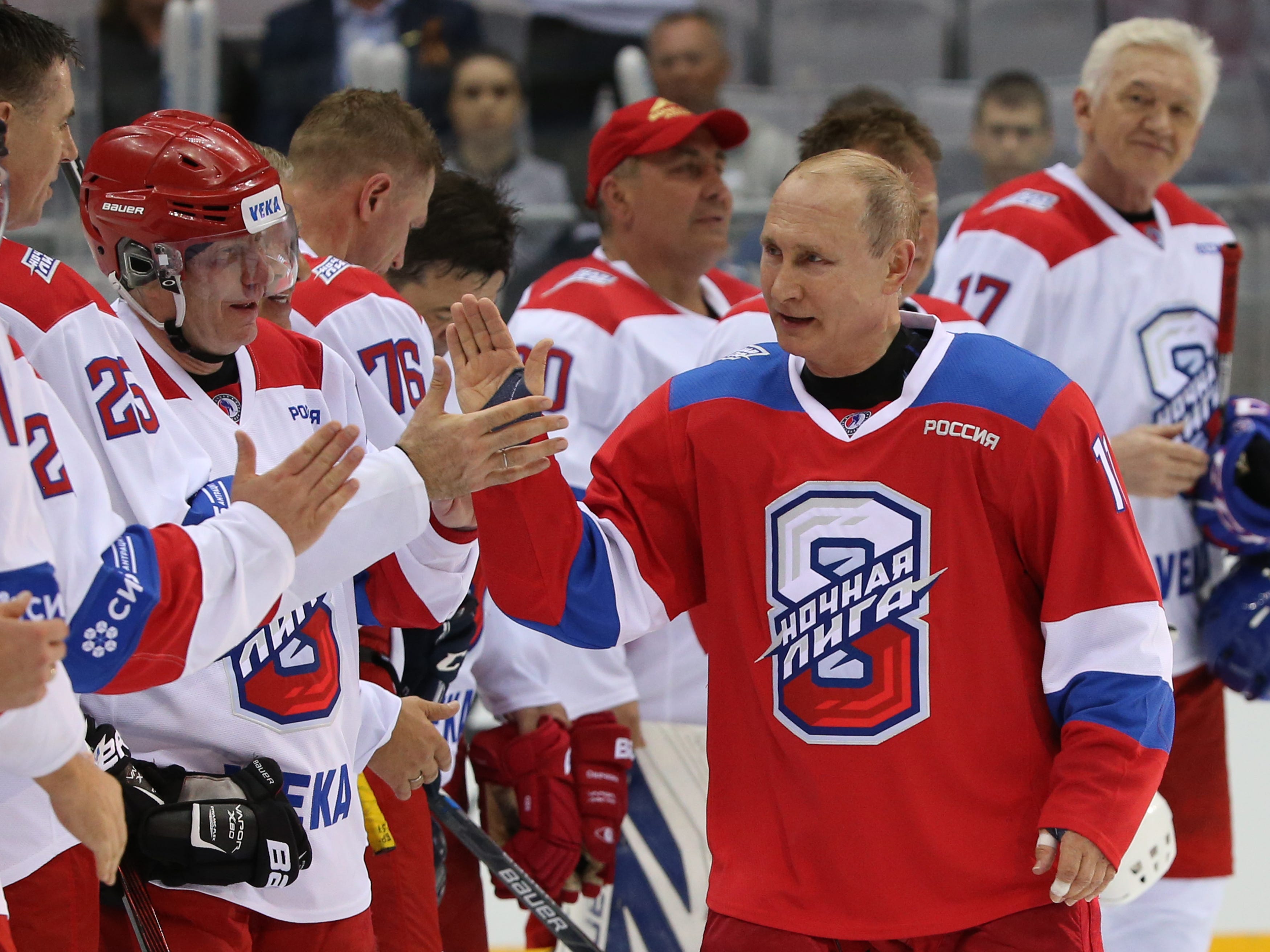 Der russische Präsident Wladimir Putin (Mitte) begrüßt den Milliardär und Geschäftsmann Wladimir Potanin (L), während der Milliardär Gennadi Timtschenko (R) während eines Gruppenfotos beim Galaspiel der Night Hockey League im Bolschoi Ice Dome in Sotschi, Russland, am 10. Mai zuschaut , 2019.