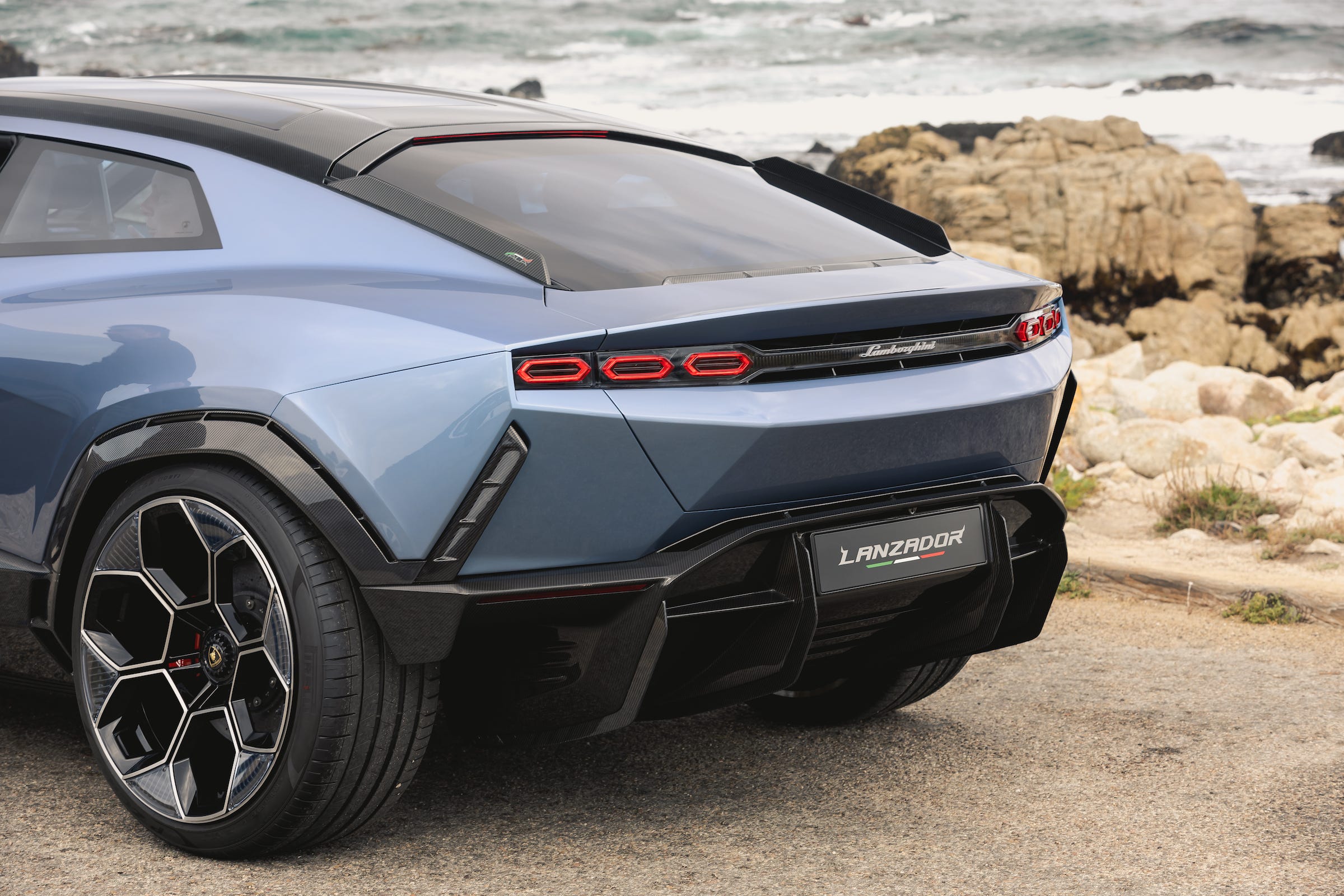 Das Heck des Konzeptautos Lamborghini Lanzador mit einem felsigen Strand im Hintergrund. 