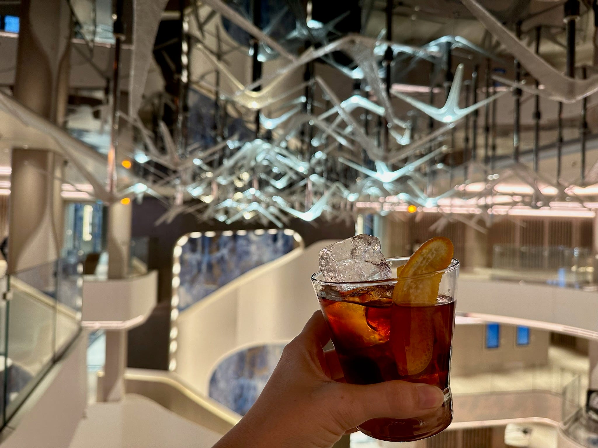 Cocktail vor einem Kunstwerk im Innenraum eines Kreuzfahrtschiffes