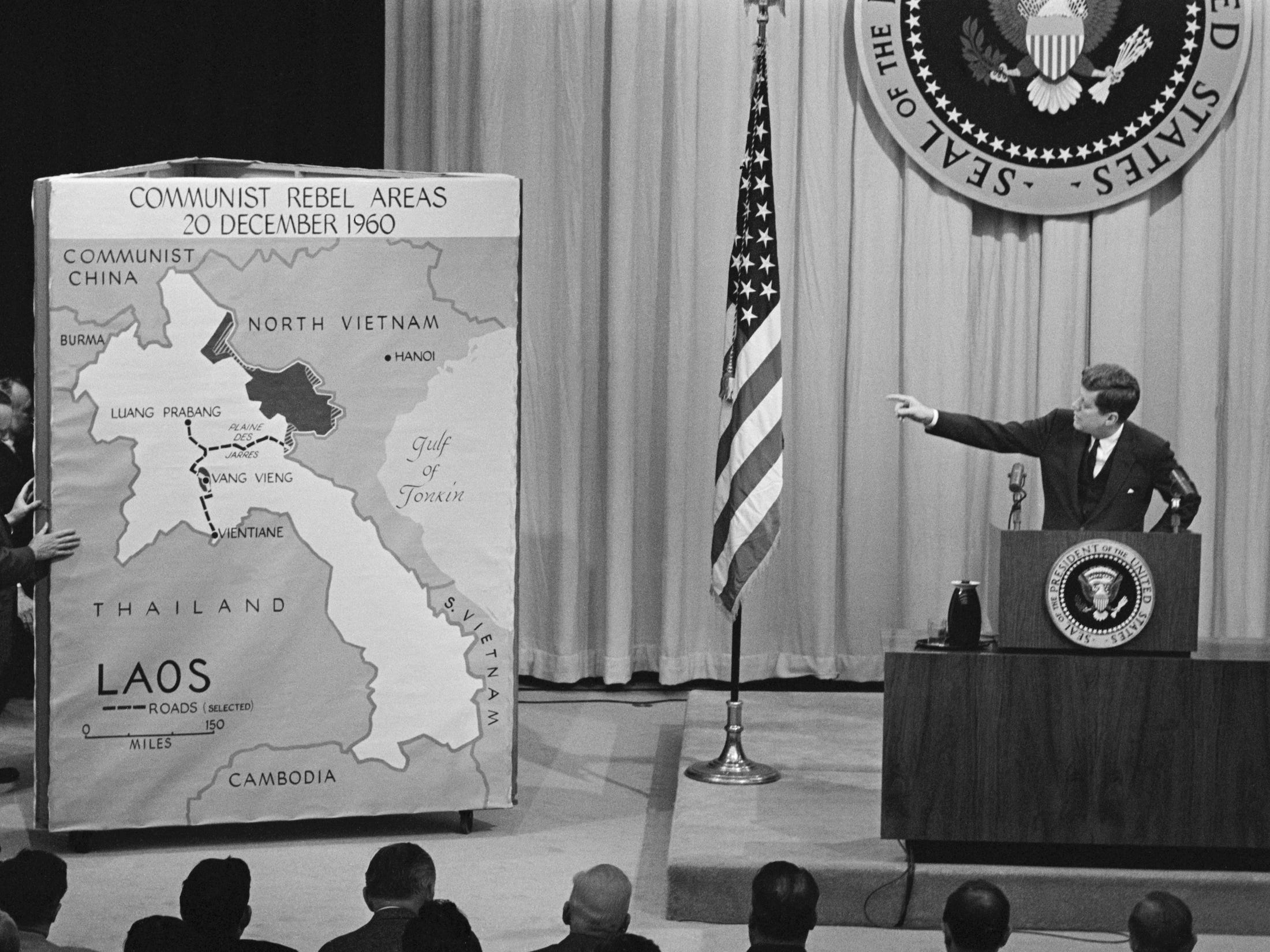 Präsident John F. Kennedy zeigt auf einer Pressekonferenz auf eine Karte von Laos.