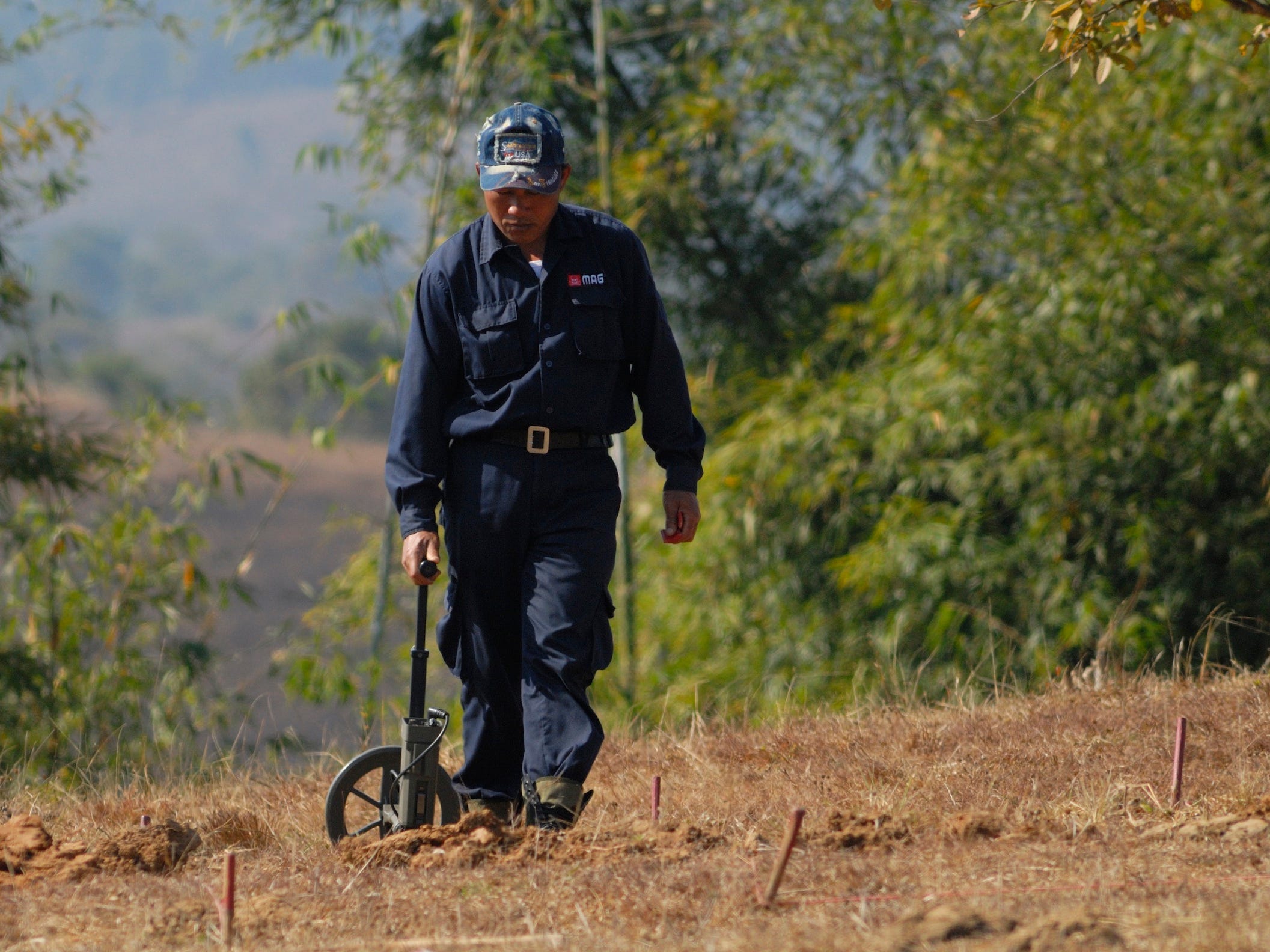 Ein Arbeiter sucht in Laos mit einem Metalldetektor nach Bomben.