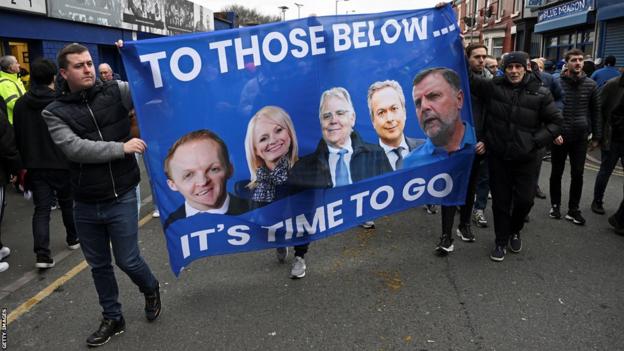Everton-Fans halten während einer Protestaktion ein Banner mit Porträts des Besitzers Farhad Moshiri (zweiter von rechts) und der Vorstandsmitglieder (von links) Grant Ingles, Denise Barrett-Baxendale, Bill Kenwright und Graeme Sharp