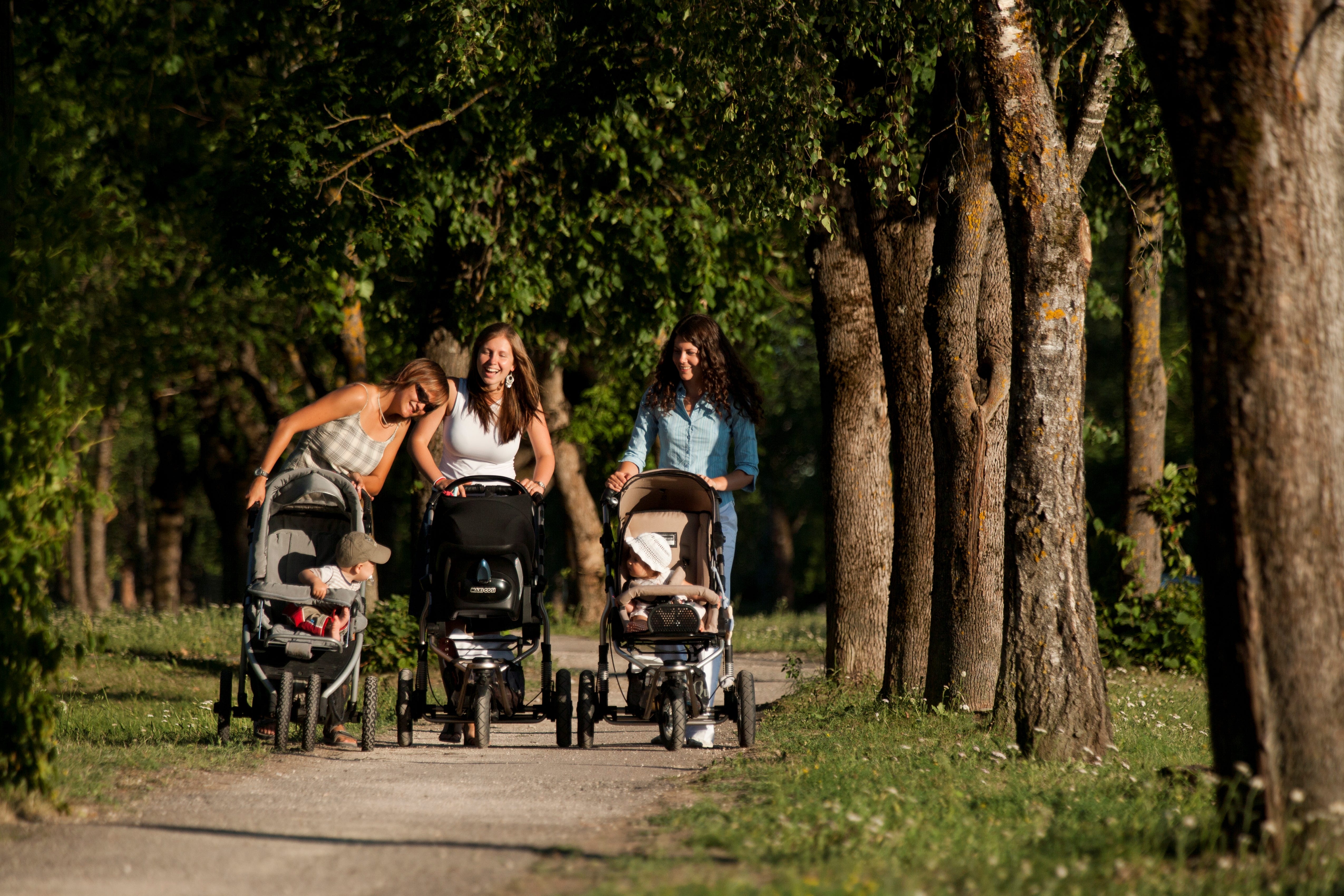 Junge Mütter gehen mit Babys spazieren