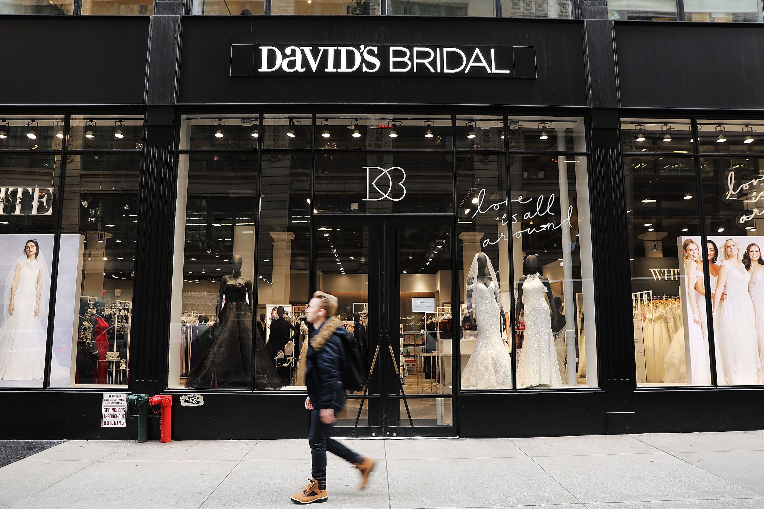 Eine Person geht an der Außenfassade von David's Bridal Store vorbei