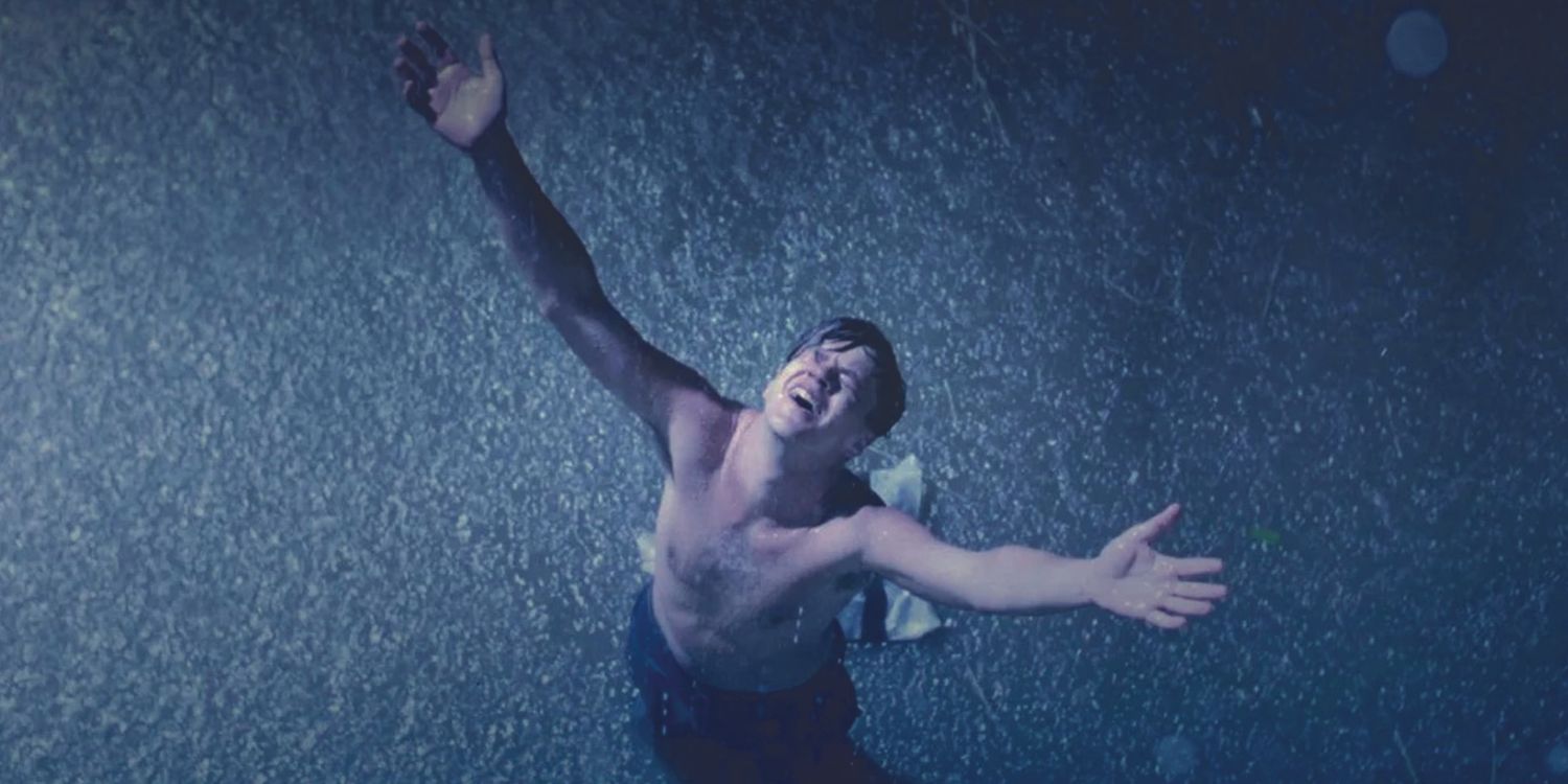 Tim Robbins steht in „The Shawshank Redemption“ mit zum Himmel erhobenen Armen im Regen.