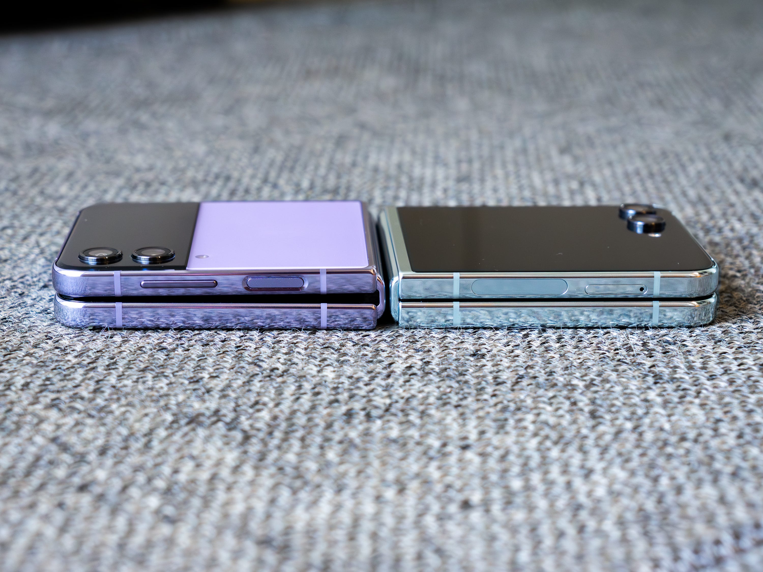 Das Samsung Galaxy Z Flip 4 und Z Flip 5 liegen im zusammengeklappten Zustand nebeneinander und zeigen große Unterschiede in ihren Scharnieren.