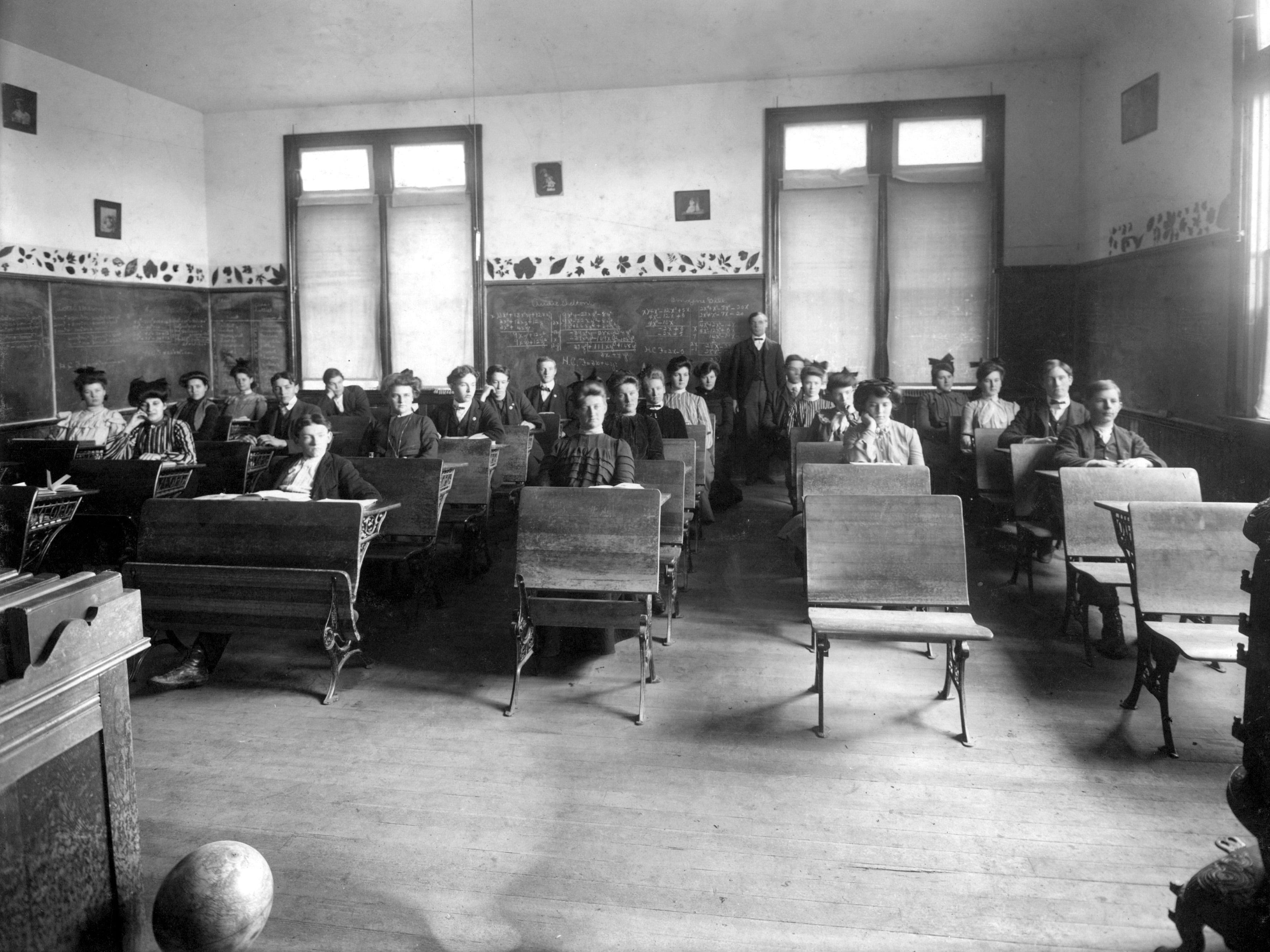 Gymnasiasten auf Schreibtischen, Mitte des 20. Jahrhunderts