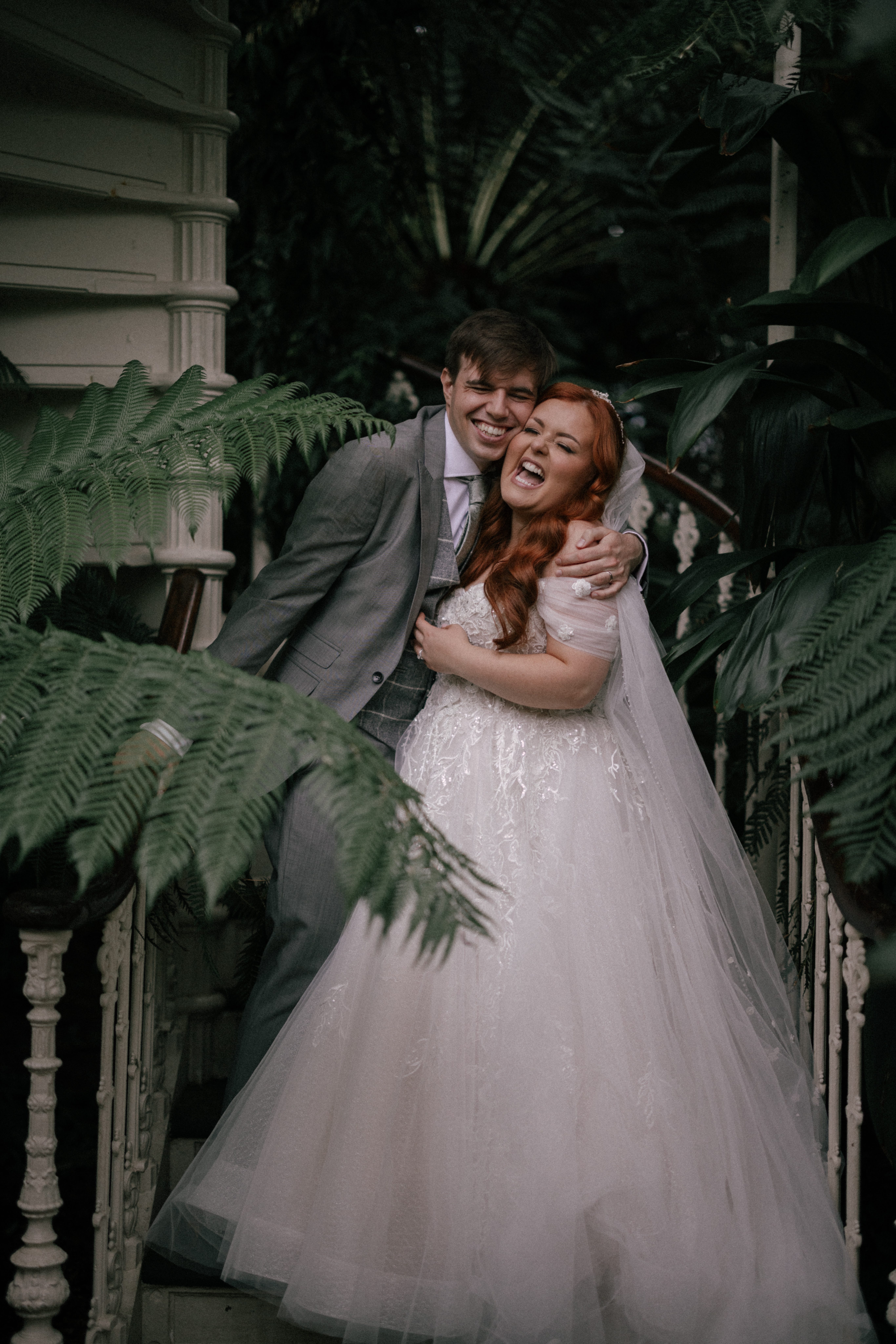Lucy Edwards und Ollie Cave umarmen sich in ihrer Hochzeitskleidung.