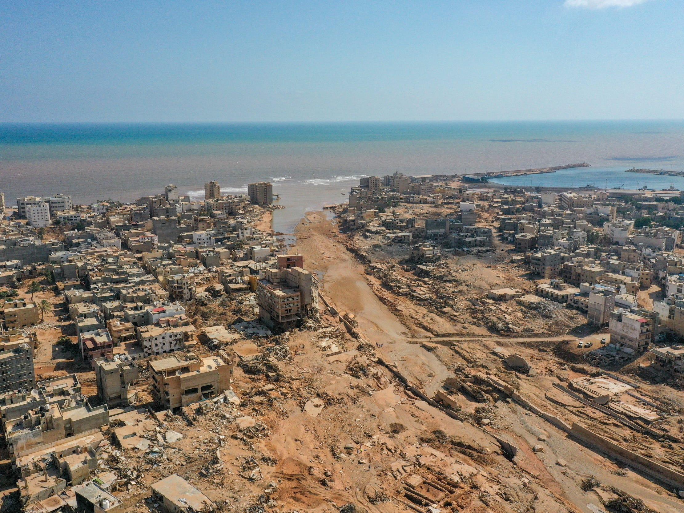 Ein Foto des Ozeans, der eine Woche nach den verheerenden Überschwemmungen in eine Straße in Libyen einbricht.