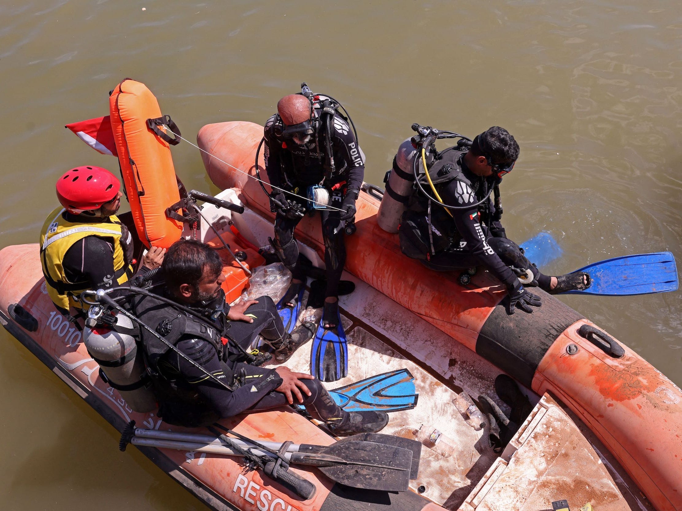 Ein Foto von Männern in einem Boot, die sich darauf vorbereiten, zu tauchen und nach Leichen zu suchen.
