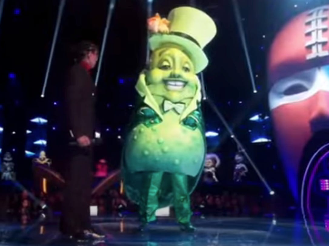 In der 10. Staffel von „The Masked Singer“ ist eine Berühmtheit in einem riesigen Pickle-Kostüm auf der Bühne zu sehen.