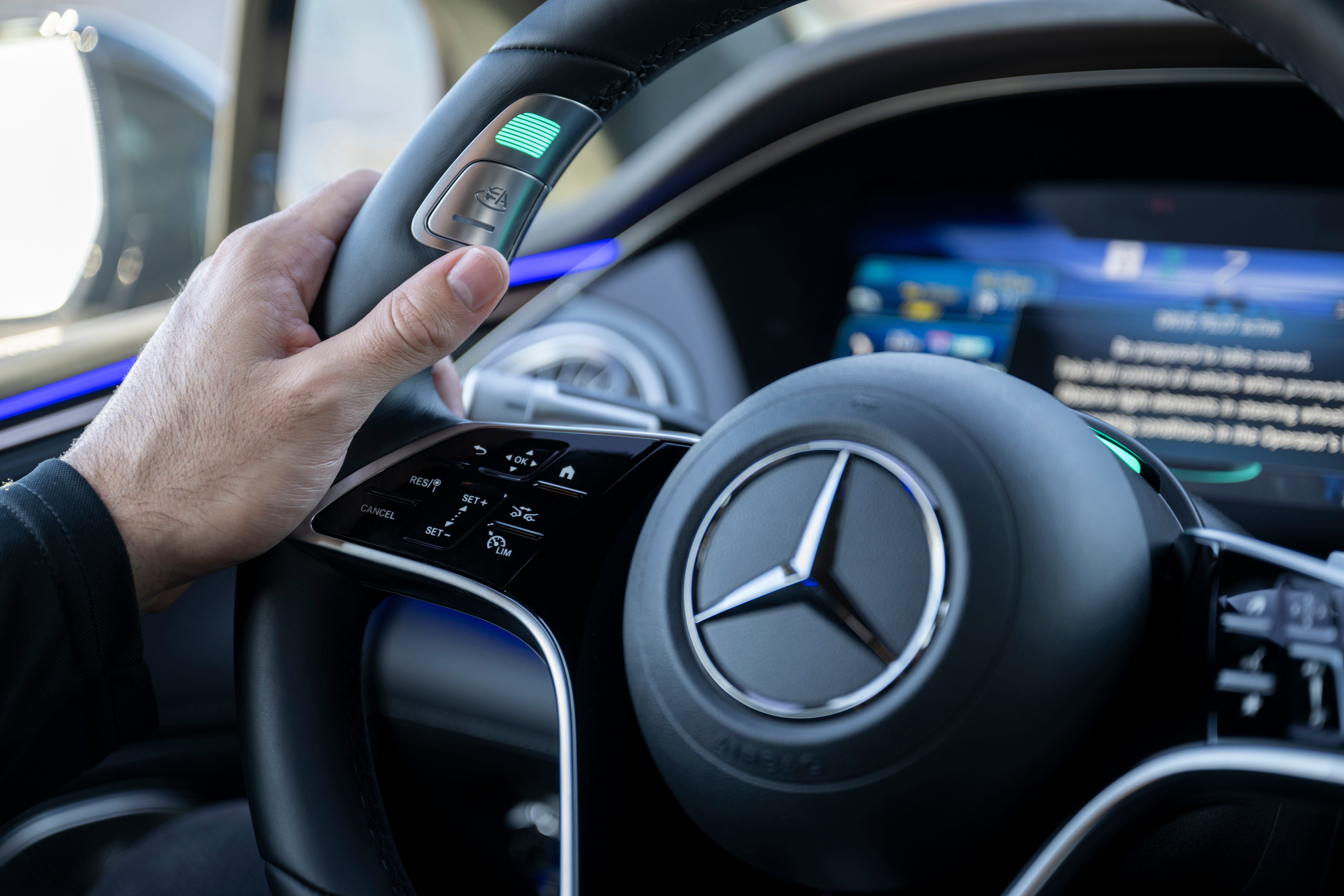 Eine Nahaufnahme des Mercedes-Benz-Lenkrads mit Drive-Pilot-Taste. 