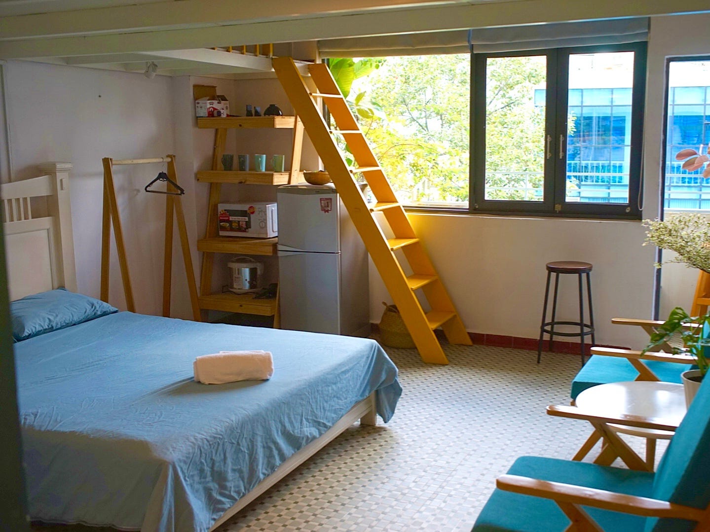 Zimmer mit einem Zwischengeschoss und einem kleinen Balkon mit Blick auf die Straße darunter