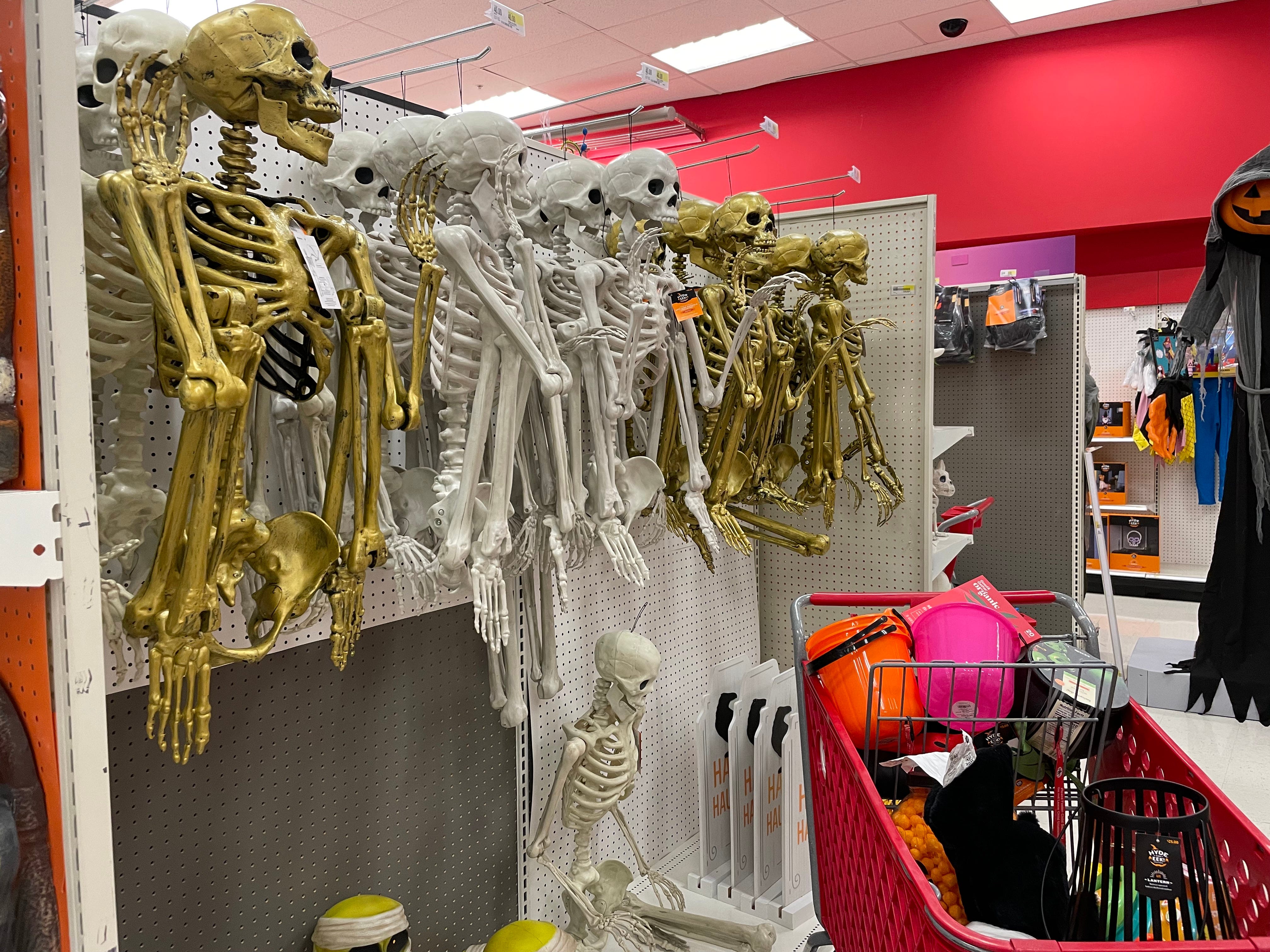 Goldene und weiße Skelettdekorationen hängen an Regalen in Target