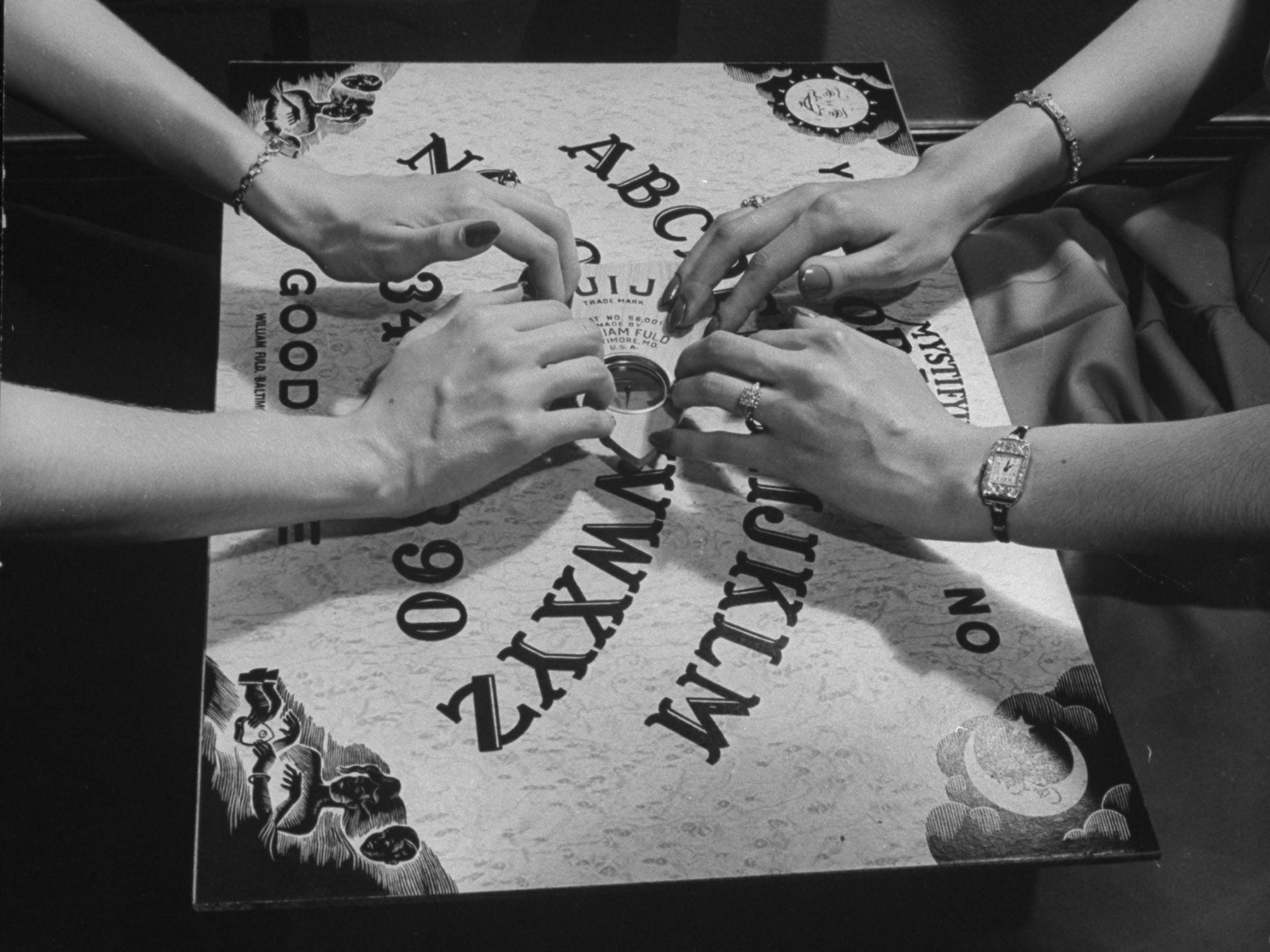 Menschen, die mit einem Ouija-Brett spielen.