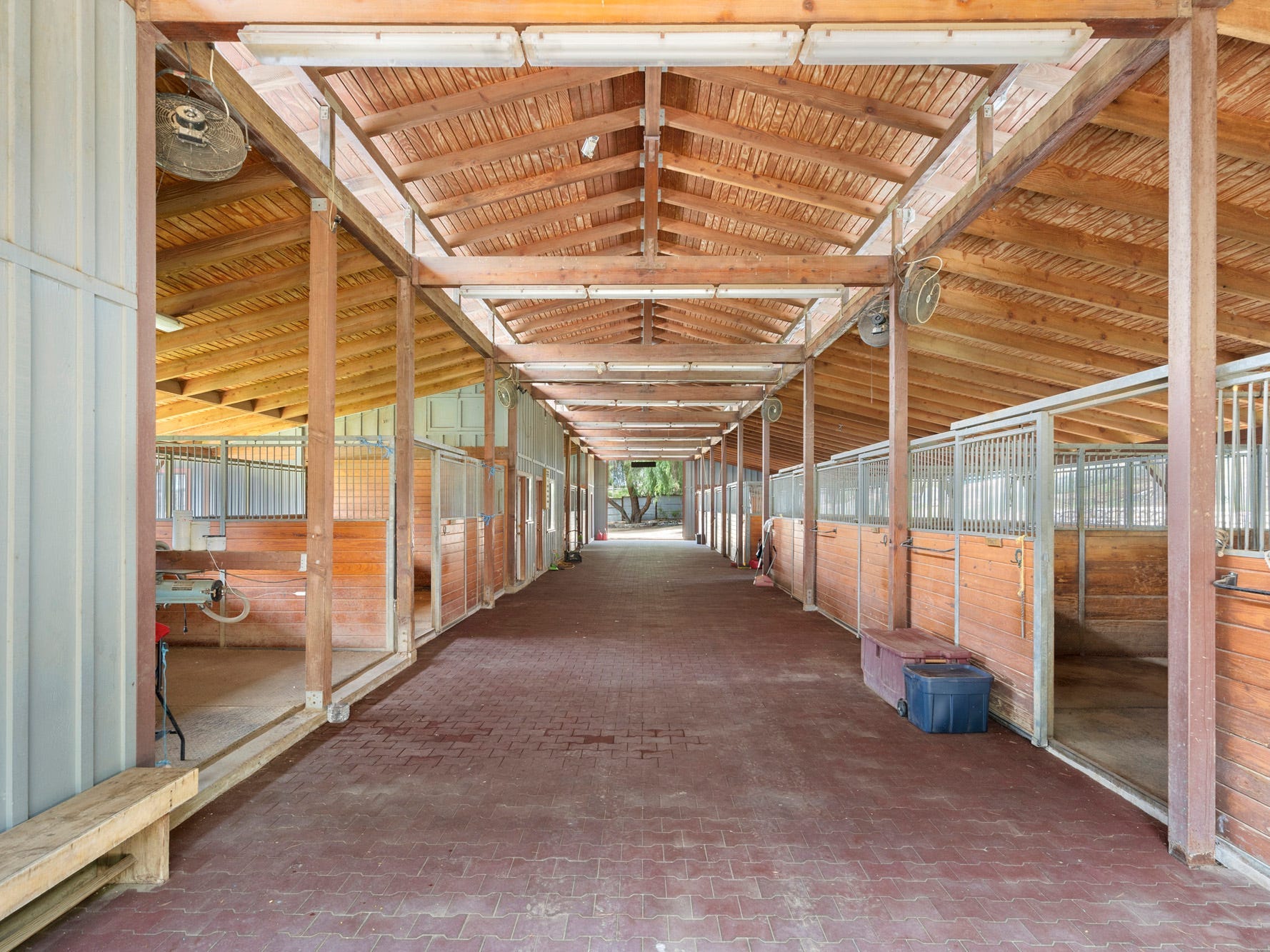 Ein Holzgebäude mit einer großen Halle und Pferdeställen an den Seiten