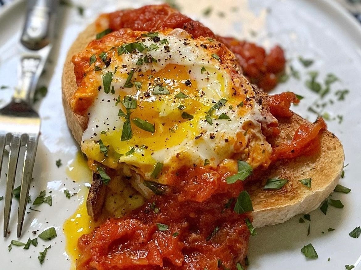 Ei mit Tomaten und Toast auf dem Teller