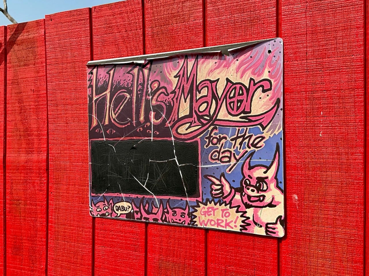 Tafel mit der Aufschrift „Hell's Mayor for the day“ und Kritzeleien von Teufeln 