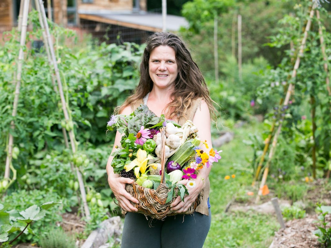 Eine Frau hält ihre Ernte in einem Garten