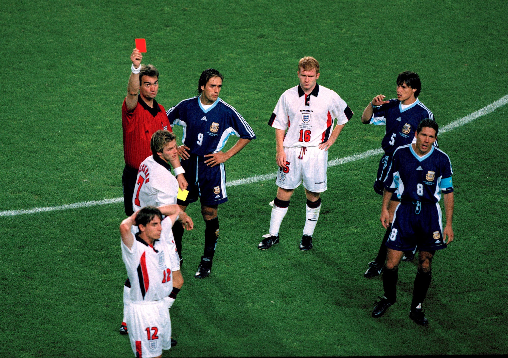 England gegen Argentinien – Schiedsrichter Kim Milton Nielsen zeigt David Beckham die rote Karte, während Paul Scholes (16) den argentinischen Kapitän Diego Simeone (8), der in den Vorfall verwickelt war, Gary Neville (12), Gabriel Batistuta (9) und Matias anklagend ansieht Almeyda (5).