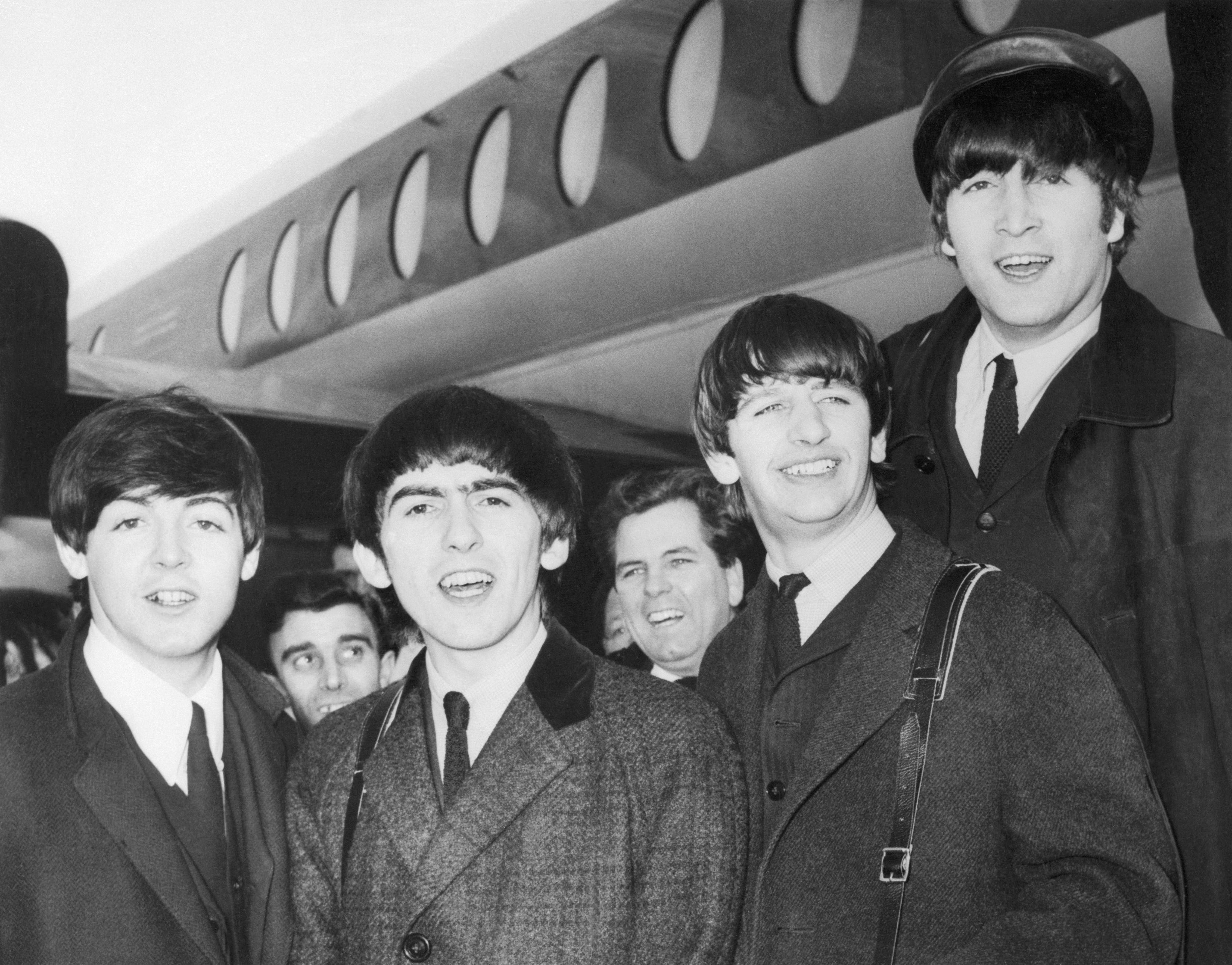 Die Beatles: (von links nach rechts) Paul McCartney;  George Harrison, Ringo Starr und John Lennon bei ihrer Ankunft 1964 am Flughafen Heathrow aus Paris, wo sie in der Olympia Music Hall auftraten.