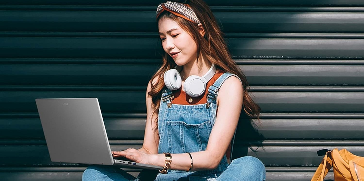 Ein Mädchen, das draußen einen Acer Swift Go-Laptop benutzt