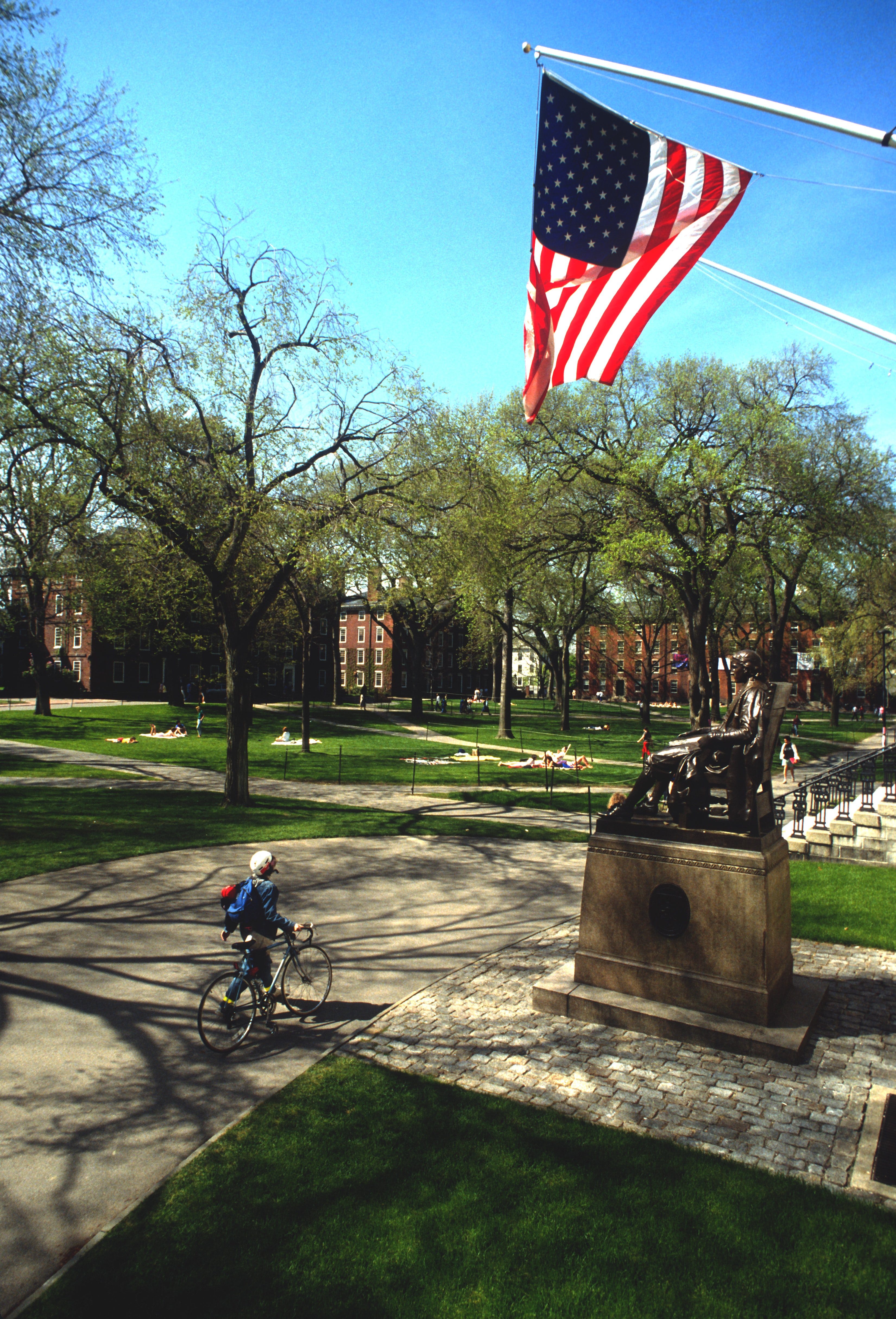Ein Foto eines Studenten, der mit dem Fahrrad auf dem Harvard Yard unterwegs ist.