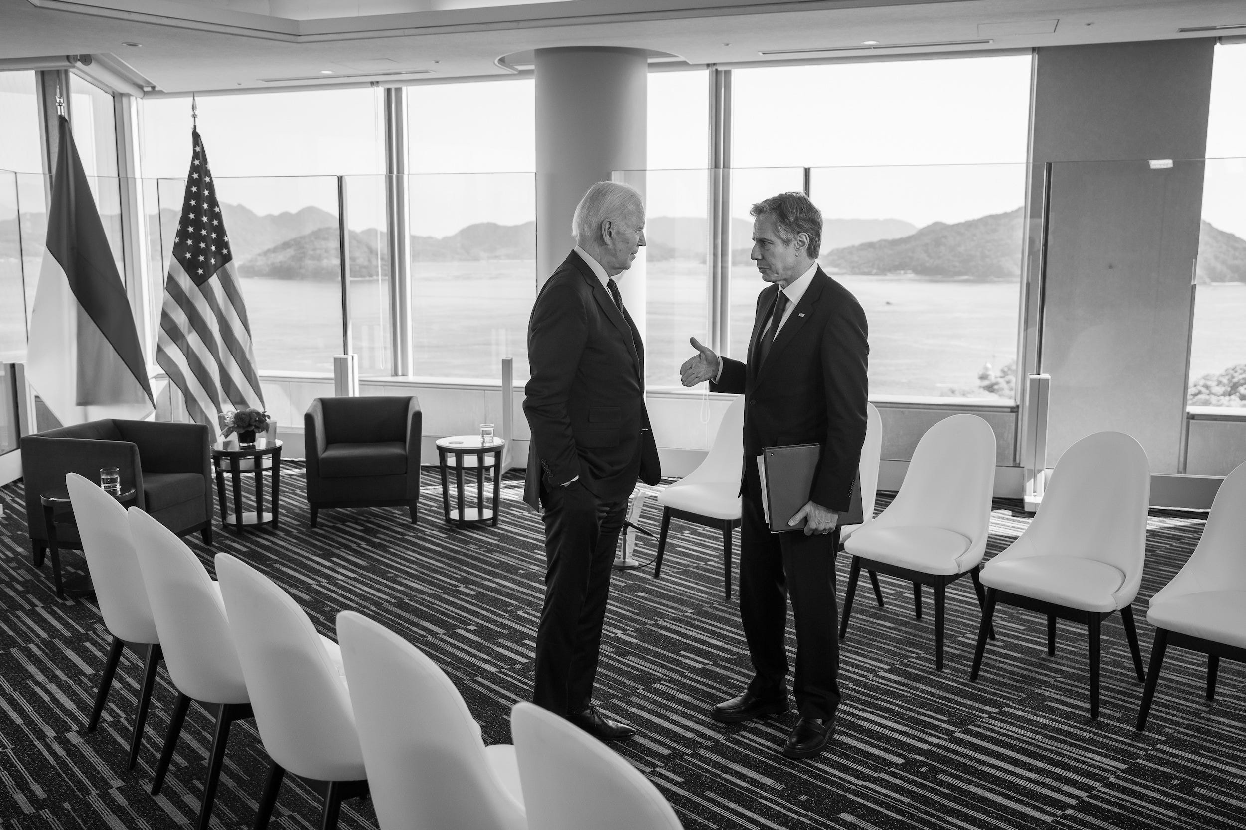 Ein Schwarz-Weiß-Foto von Antony Blinken im Gespräch mit Präsident Biden.