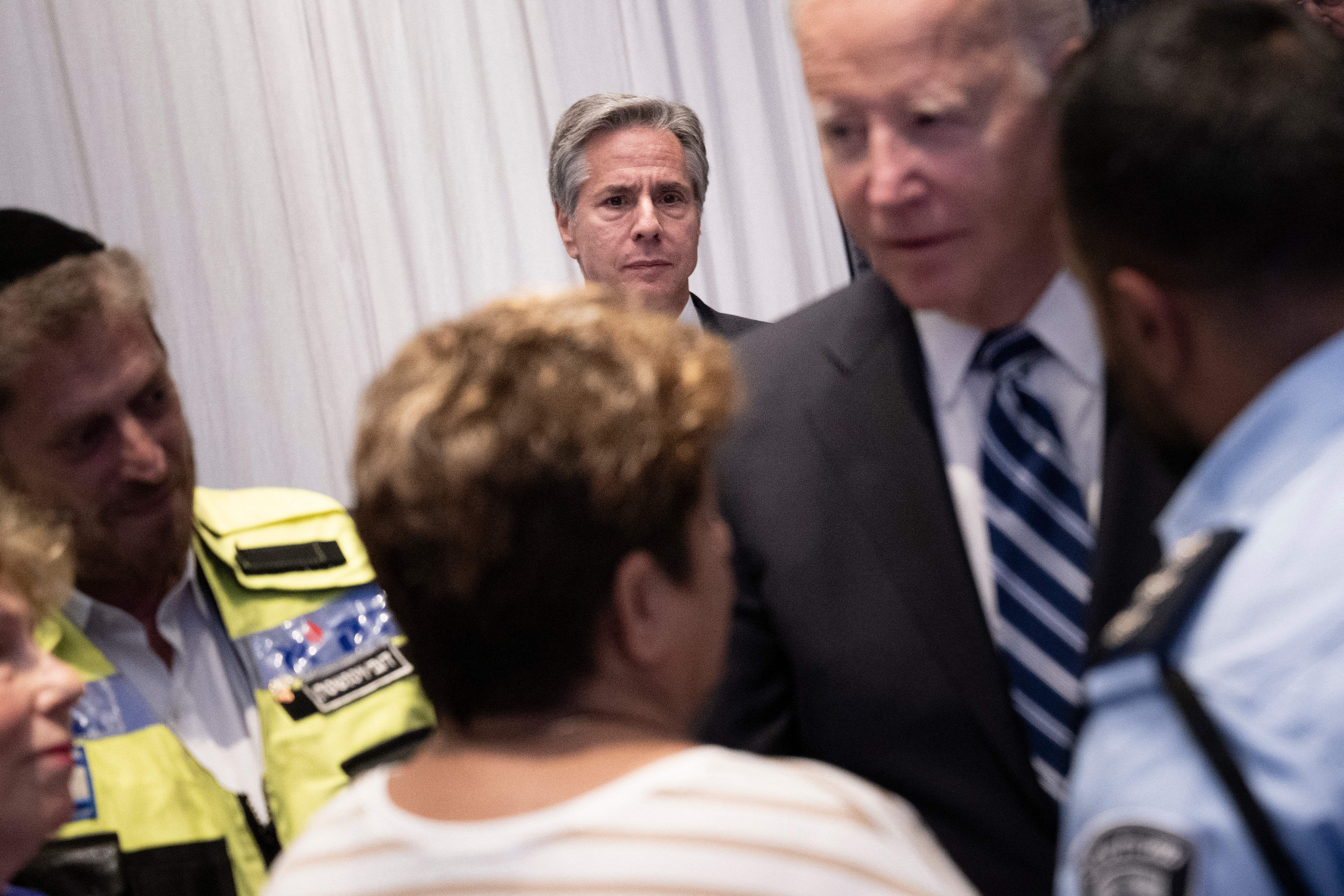 Ein Foto von Antony Blinken, der zusieht, wie Präsident Biden mit anderen spricht.