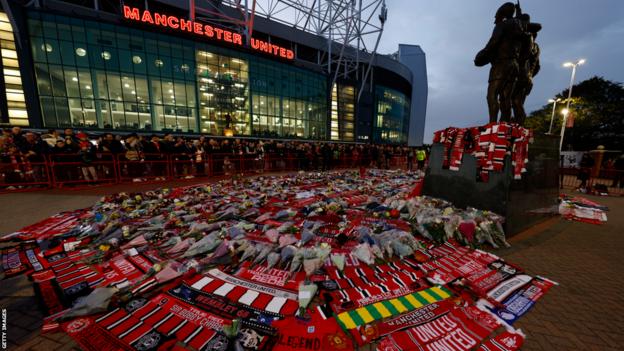 Schals und Blumen vor Old Trafford vor dem ersten Heimspiel von Manchester United seit dem Tod der Vereinslegende Sir Bobby Charlton