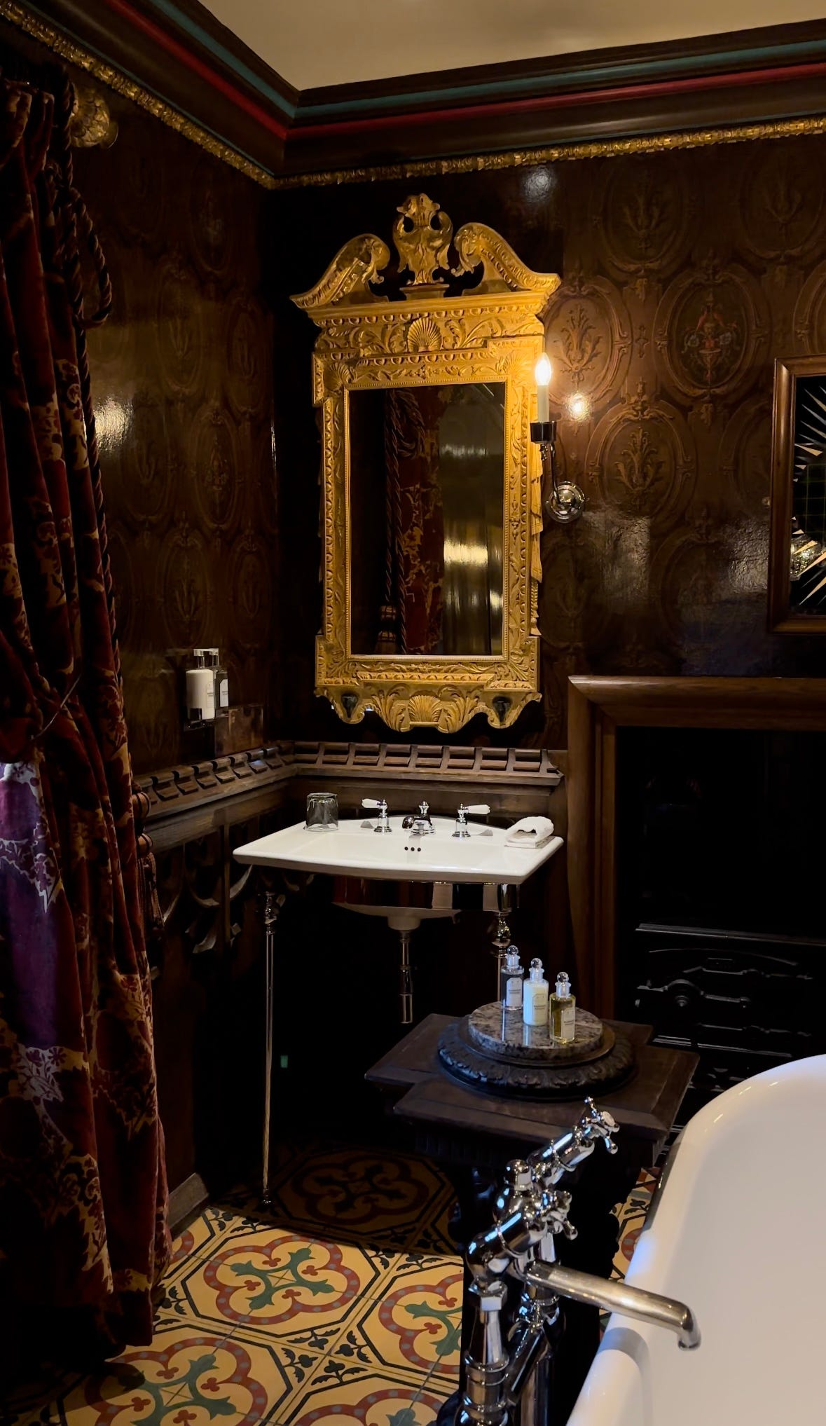 Ein Doppelwaschbecken mit goldenem Spiegel und Mahagoniwänden.
