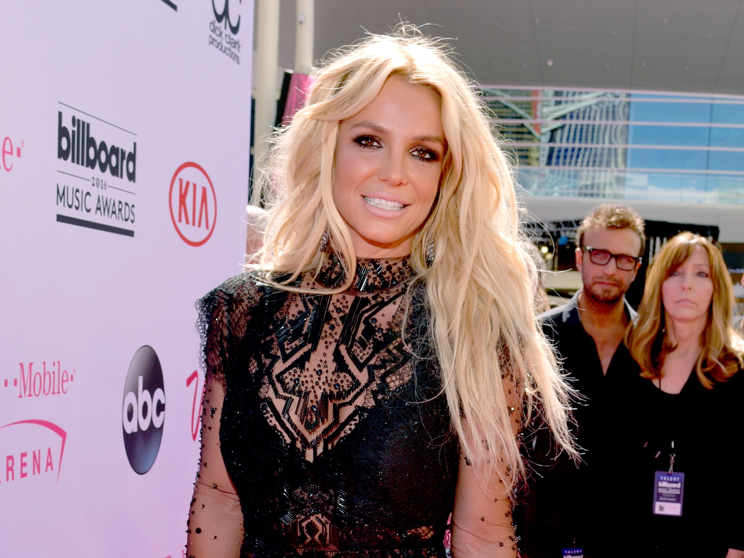Britney Spears lächelt in einem schwarzen Spitzenkleid