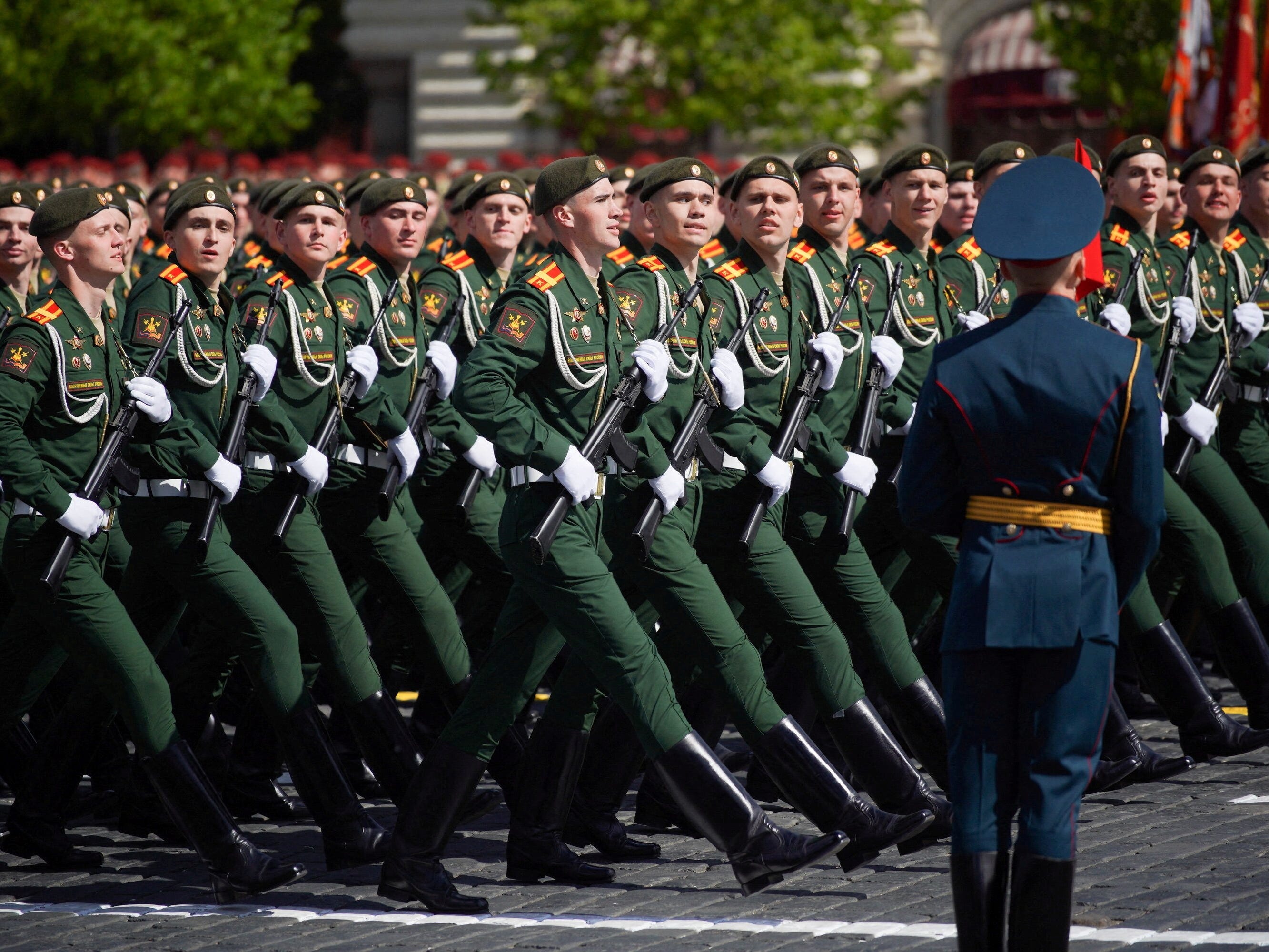 Russische Soldaten marschieren gemeinsam unter der Aufsicht eines hochrangigen Militärbeamten.