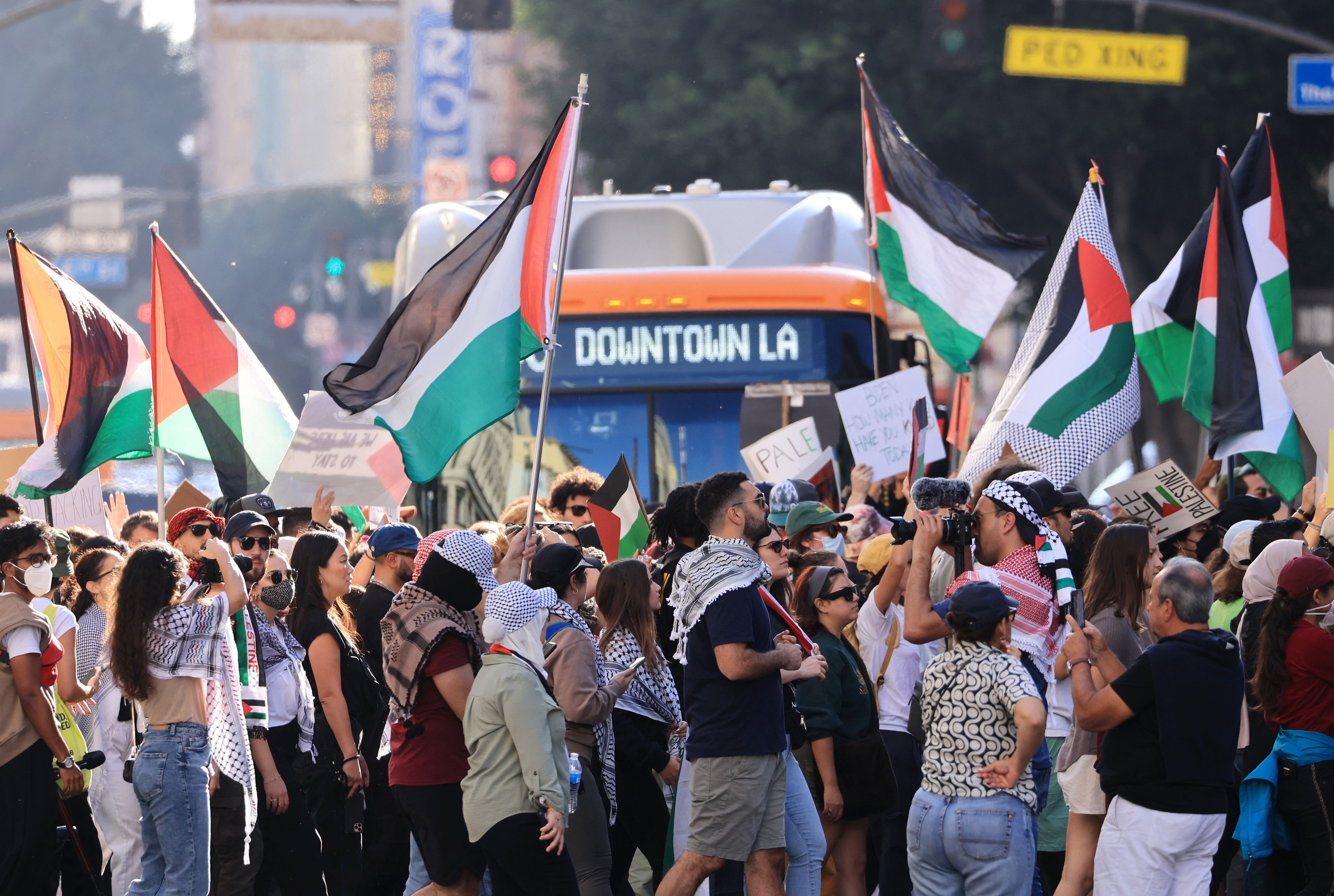 Demonstranten schwenken die palästinensische Flagge und marschieren vor einem Bus in Los Angeles, Kalifornien.