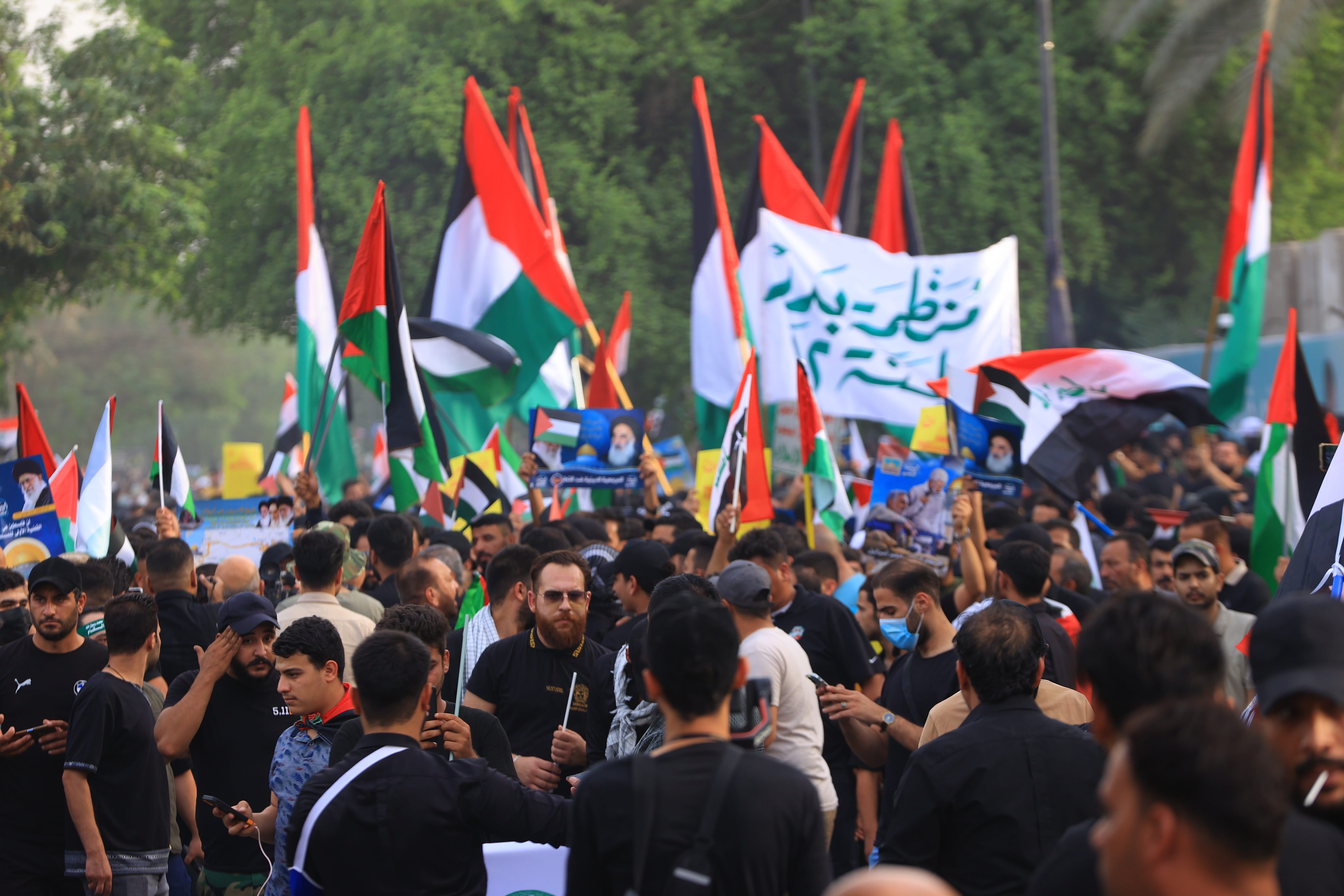 Demonstranten marschieren und hissen die palästinensische Flagge in Bagdad, Irak.