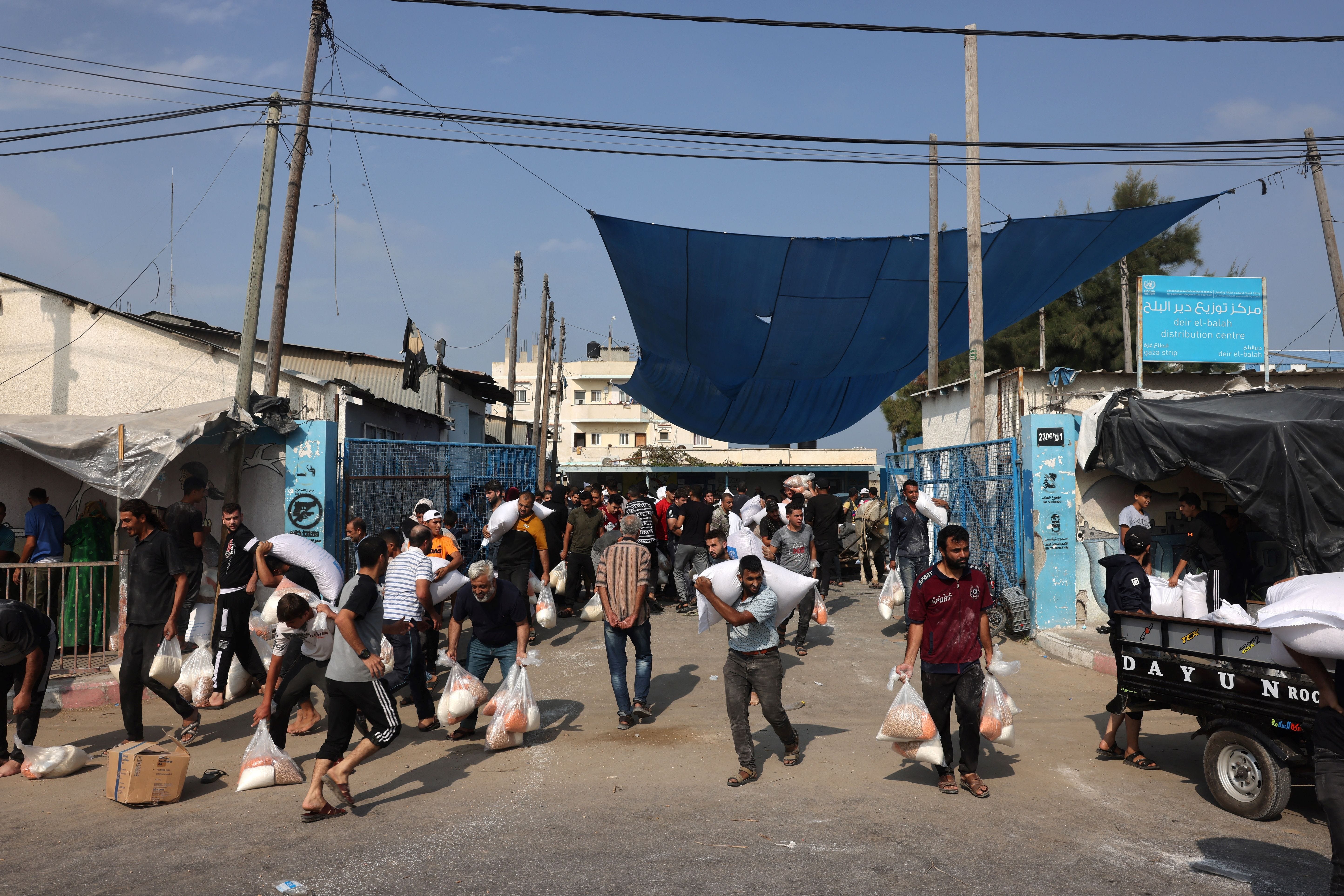 Palästinenser stürmen am 28. Oktober 2023 inmitten der anhaltenden Kämpfe in Deir al-Balah ein von den Vereinten Nationen betriebenes Hilfsversorgungszentrum, das Lebensmittel an vertriebene Familien verteilt, nachdem Israel mehr als eine Million Einwohner im nördlichen Gazastreifen aufgefordert hatte, zu ihrer Sicherheit nach Süden zu ziehen zwischen Israel und der palästinensischen Gruppe Hamas.