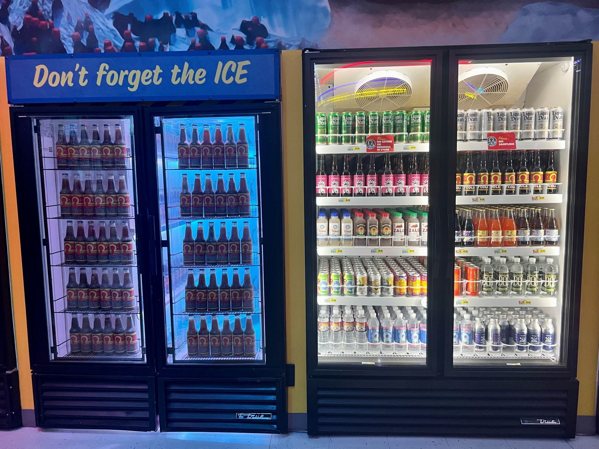 Zwei Kühlschränke nebeneinander mit Getränken.  Auf der rechten Seite gibt es echte, käufliche Getränke, auf der linken Seite ist ein gefälschter Eingang.