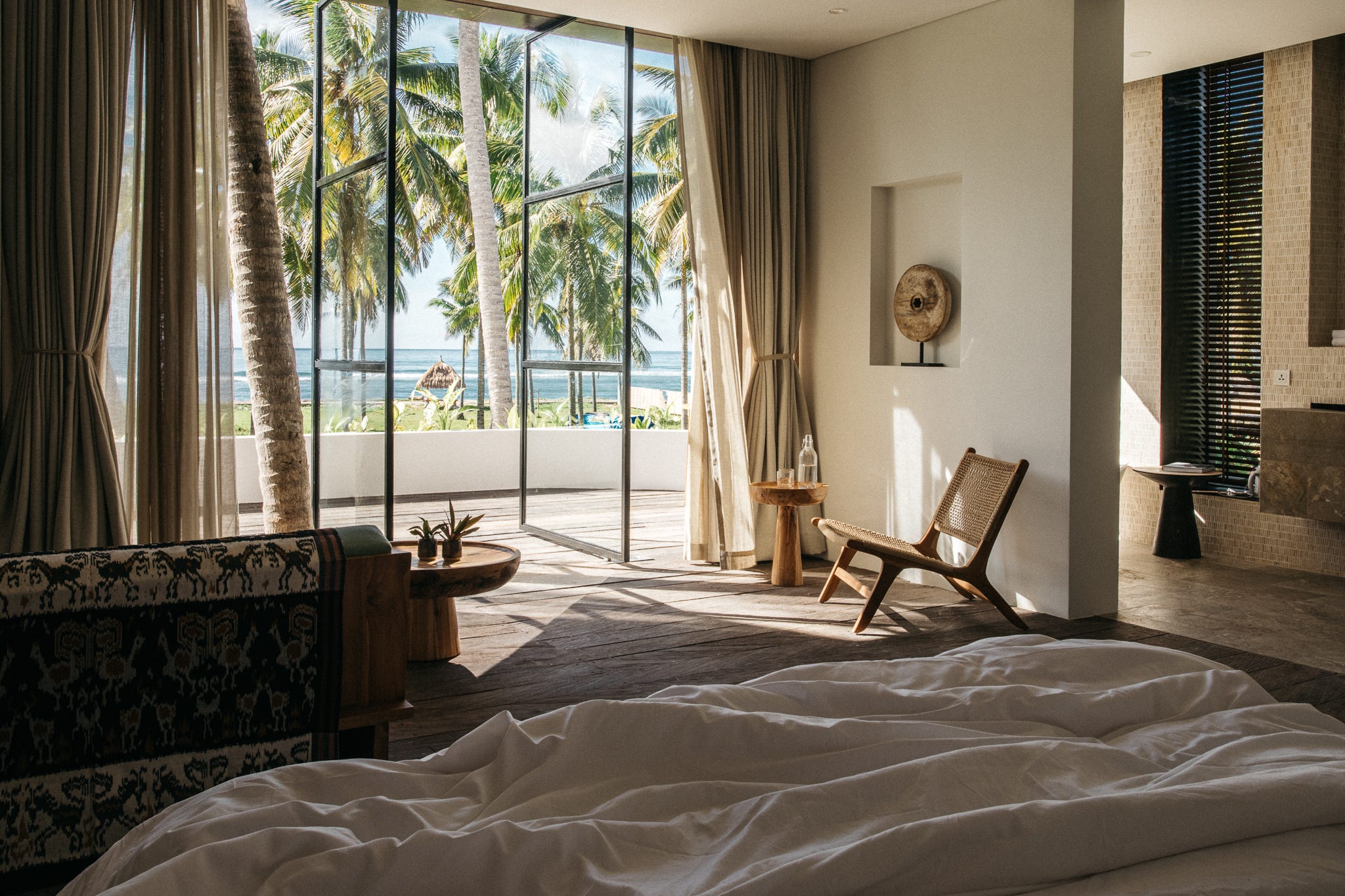Ein Hotelzimmer mit einem Bett, eigenem Bad, Sofa und einem Balkon mit Meerblick
