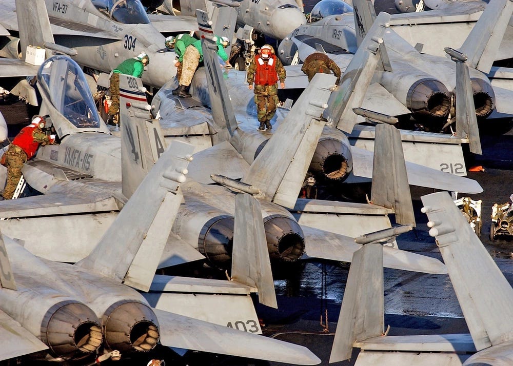 Ein Foto von Matrosen, die auf den Dächern von Kampfflugzeugen laufen.
