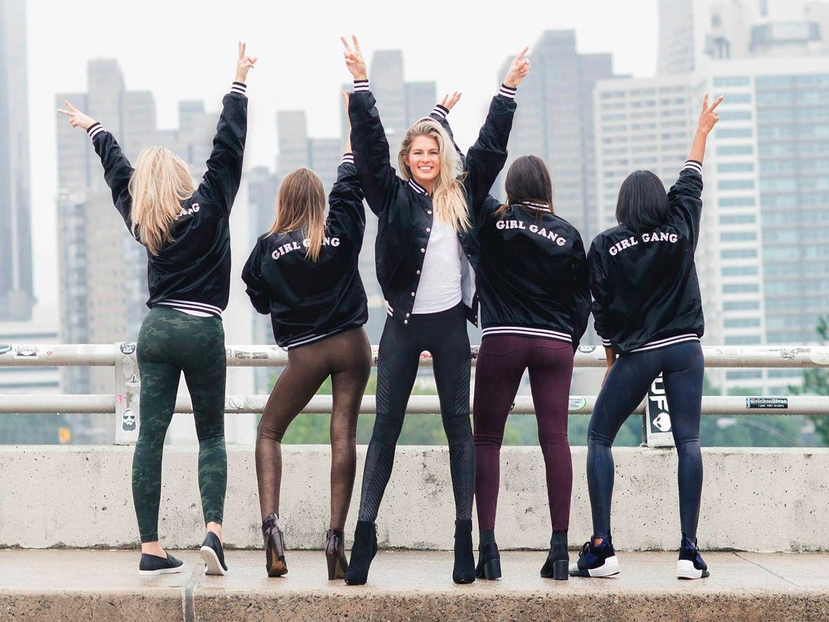 Fünf Models tragen Spanx-Leggings vor der Skyline einer Stadt.