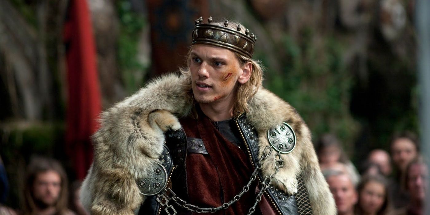 Jamie Campbell Bower als König Artus mit Narben im Mantel in Camelot